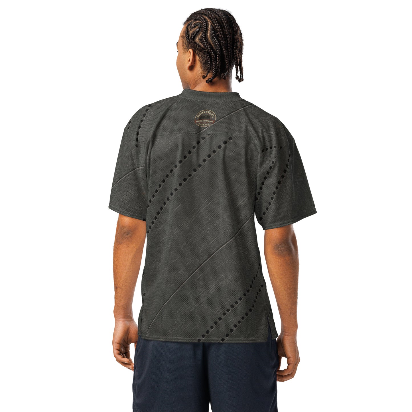 Person wearing a dark green t-shirt with a unique pattern on the back, standing against a white background.