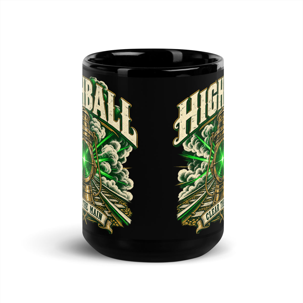 Black glossy 15 oz ceramic mug featuring a vintage brass railroad lantern shining a bright green light over train tracks surrounded by steam. Large distressed text arched at the top reads "HIGHBALL". A banner at the bottom reads "CLEAR THE MAIN" above crossed railroad spikes.