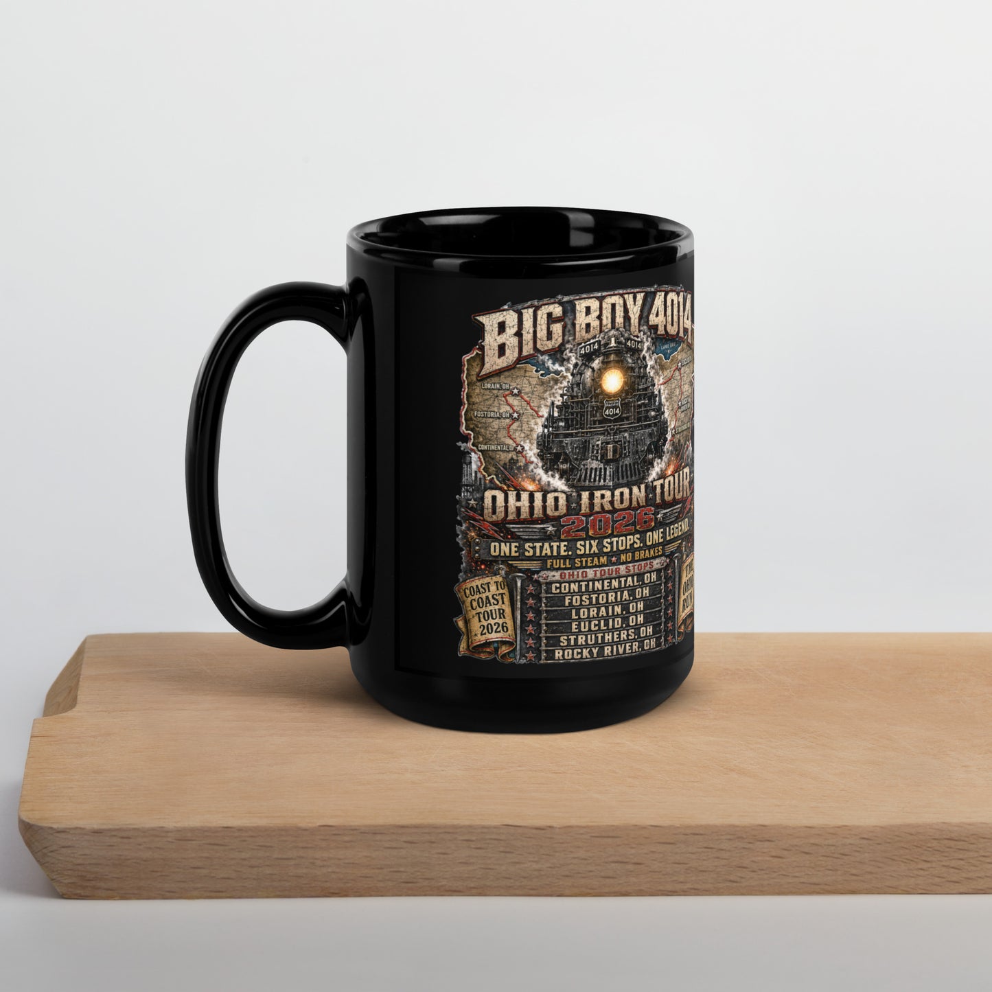 Black 15-ounce glossy coffee mug featuring a highly detailed graphic of the Big Boy 4014 steam locomotive backed by a map of Ohio. Text reads "BIG BOY 4014", "OHIO IRON TOUR 2026", "ONE STATE. SIX STOPS. ONE LEGEND.", alongside banners for "COAST TO COAST TOUR 2026" and "THE OHIO RUN", plus a detailed roster of six Ohio tour stops.
