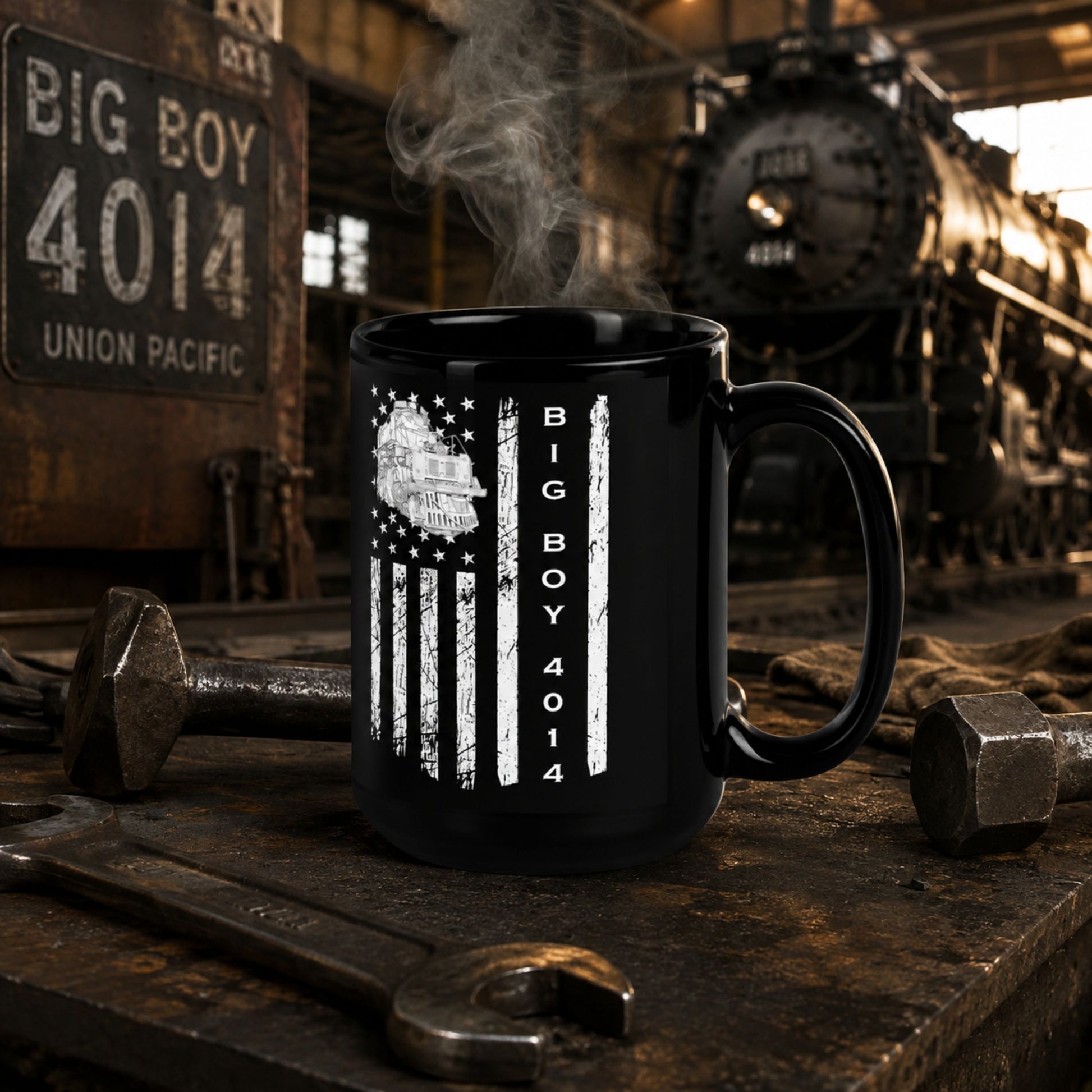 A black ceramic mug with a distressed white American flag design and vertical text reading 'BIG BOY 4014', placed on a rustic workbench with a steam train and tools in the background.