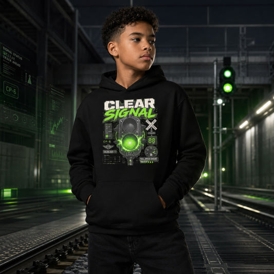A young man wearing a black hoodie with a green and white 'CLEAR SIGNAL' graphic, standing on train tracks in a futuristic, dark industrial setting with green lights.