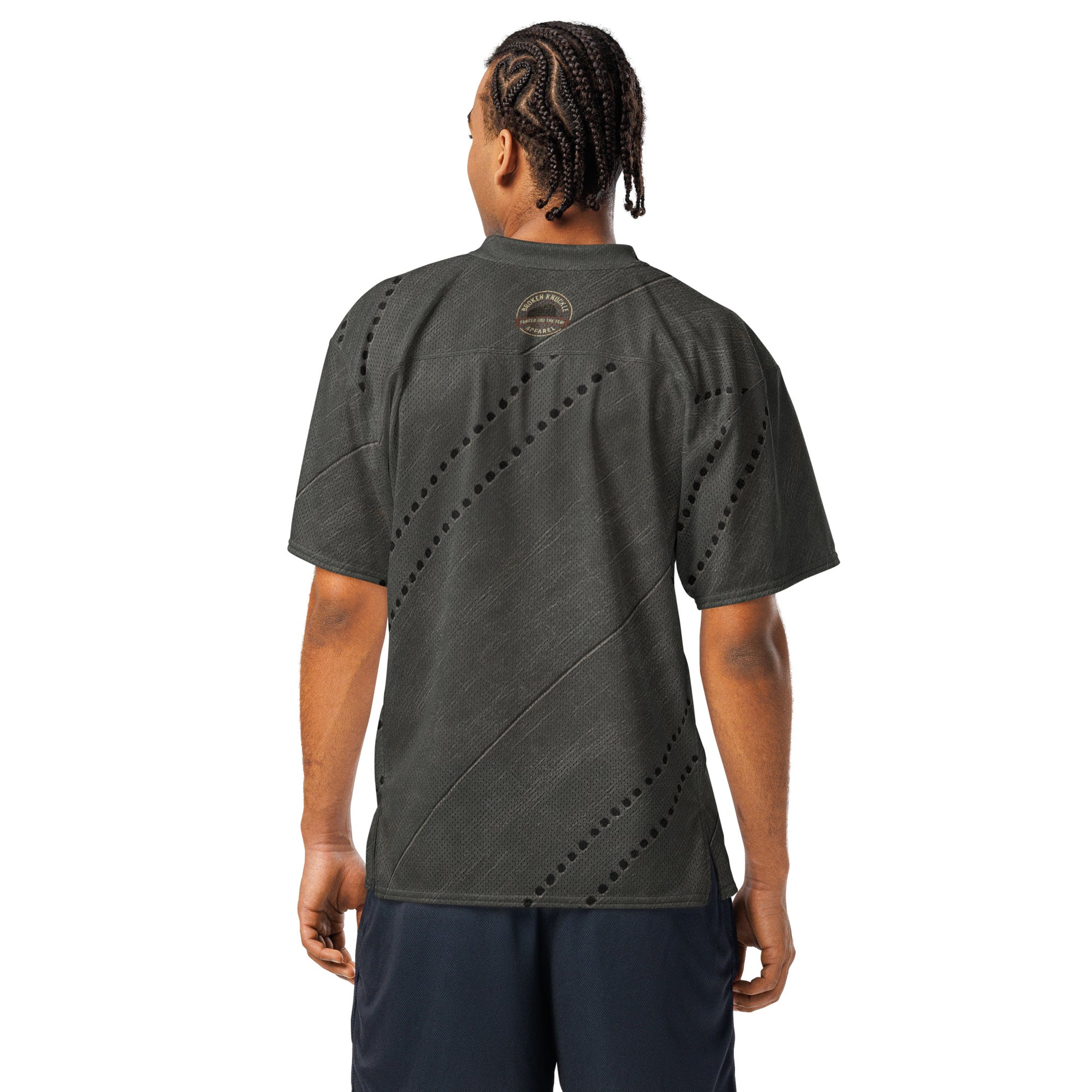 Person wearing a dark green t-shirt with a unique pattern on the back, standing against a white background.