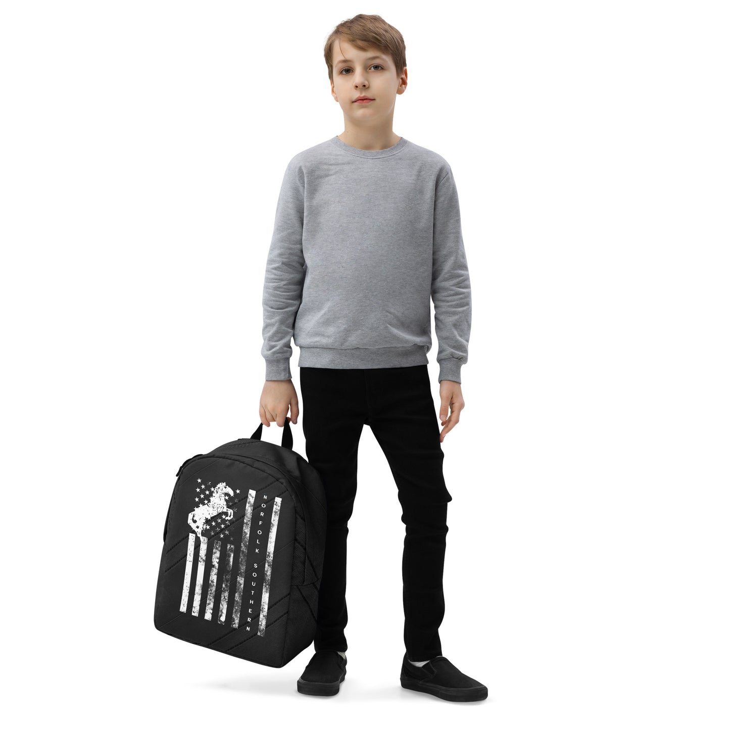 Child holding a black backpack with a design on a white background