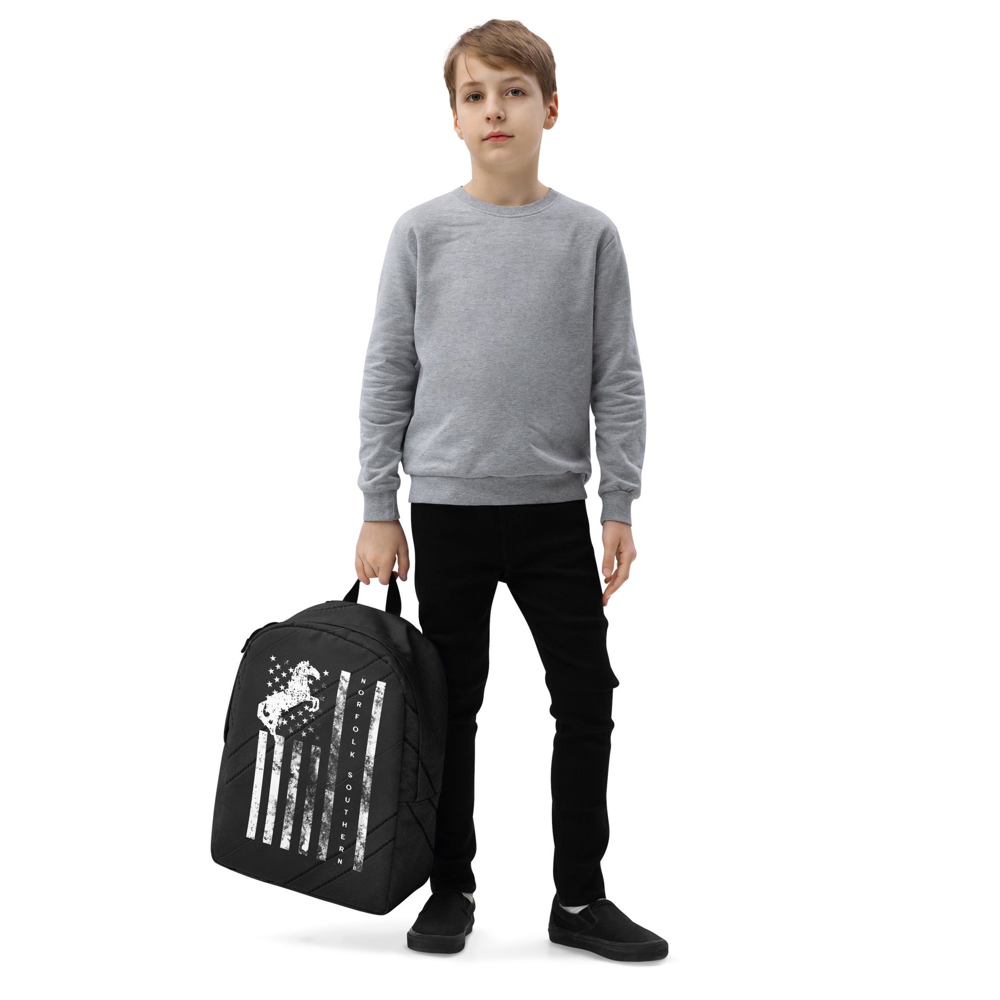 Child holding a black backpack with a design on a white background