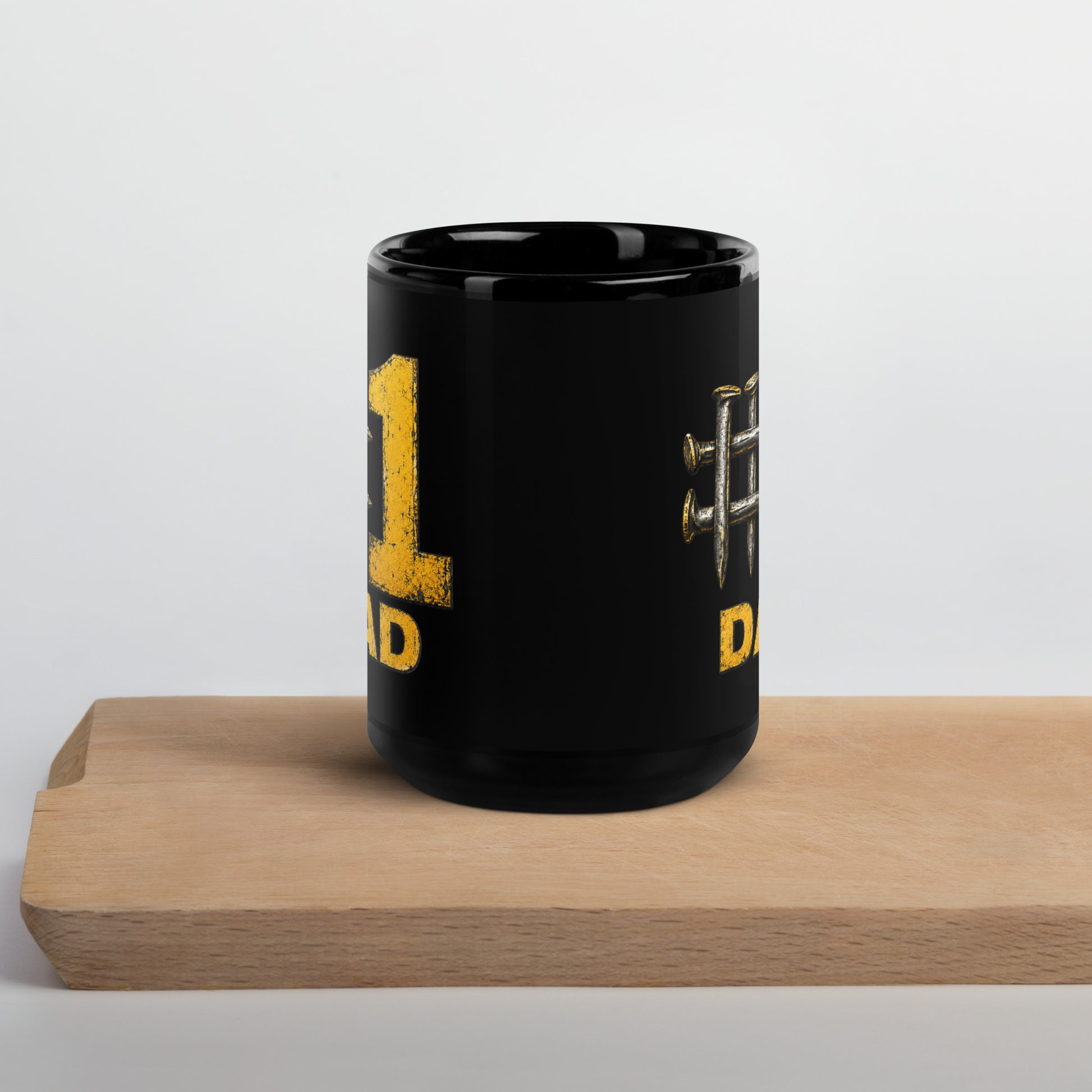 Black 15-ounce glossy coffee mug featuring a hashtag symbol made of four crossed metal railroad spikes next to a large, distressed yellow number 1, with the word DAD in matching distressed yellow text directly below.