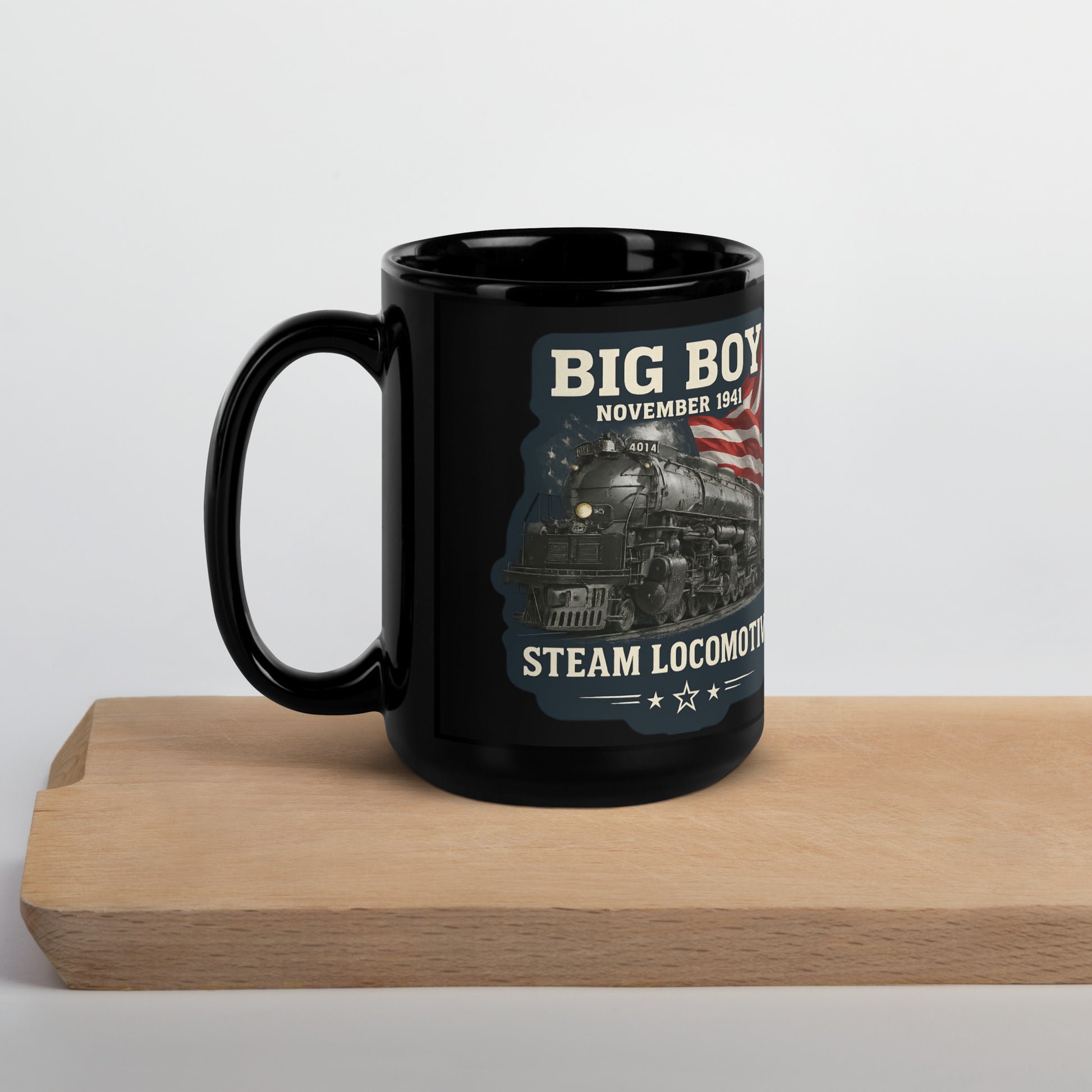Black 15-ounce glossy coffee mug featuring a vintage graphic of the Big Boy 4014 steam locomotive backed by an American flag, with text reading "BIG BOY", "NOVEMBER 1941", and "STEAM LOCOMOTIVE".