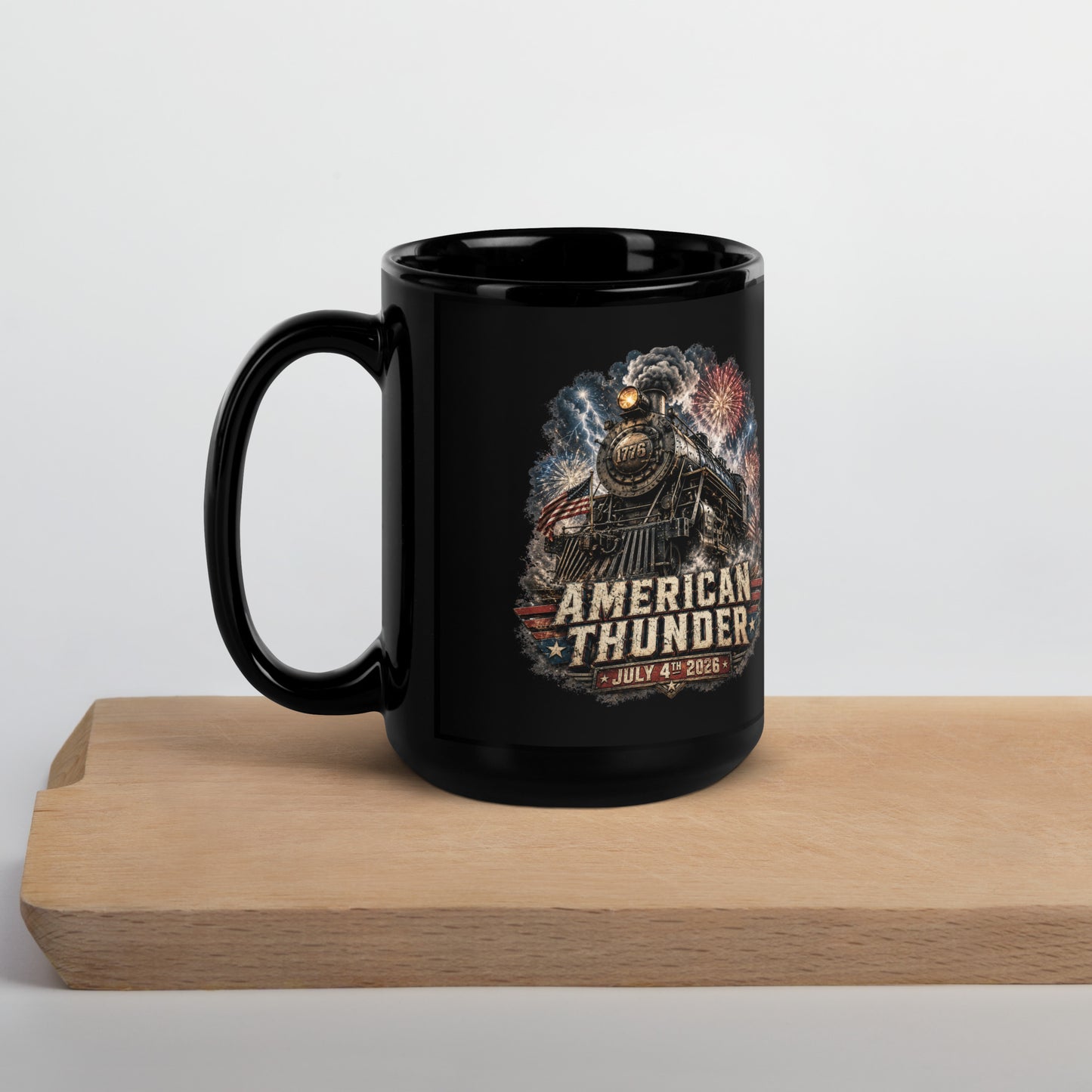 Black 15-ounce glossy coffee mug featuring a 1776 steam locomotive charging through smoke and patriotic fireworks, with an American flag and distressed text reading "AMERICAN THUNDER" over a red, white, and blue banner, followed by "JULY 4TH 2026".
