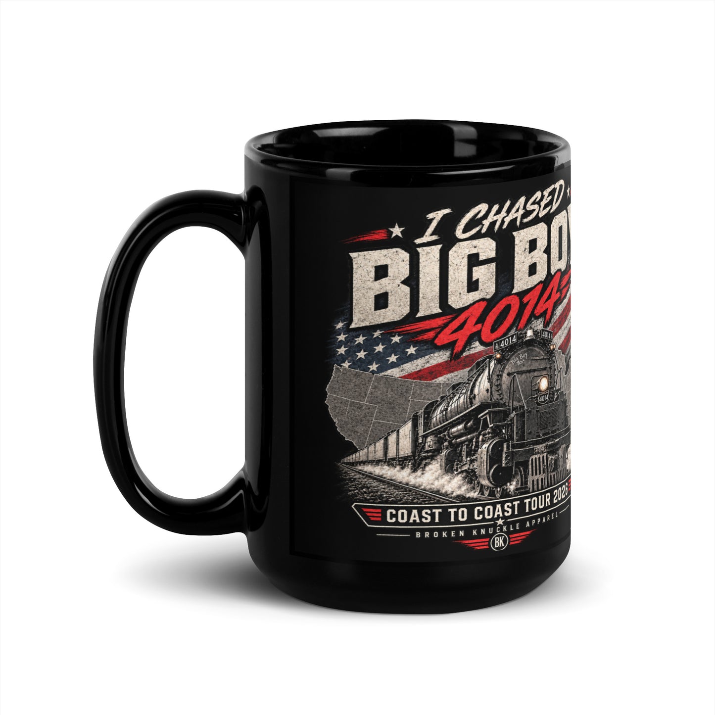 Black glossy 15 oz ceramic mug featuring a graphic of the Big Boy 4014 steam locomotive charging out of a USA map filled with the American flag. Distressed text reads "I CHASED BIG BOY 4014" at the top and "COAST TO COAST TOUR 2026" on a banner at the bottom above the Broken Knuckle Apparel logo.