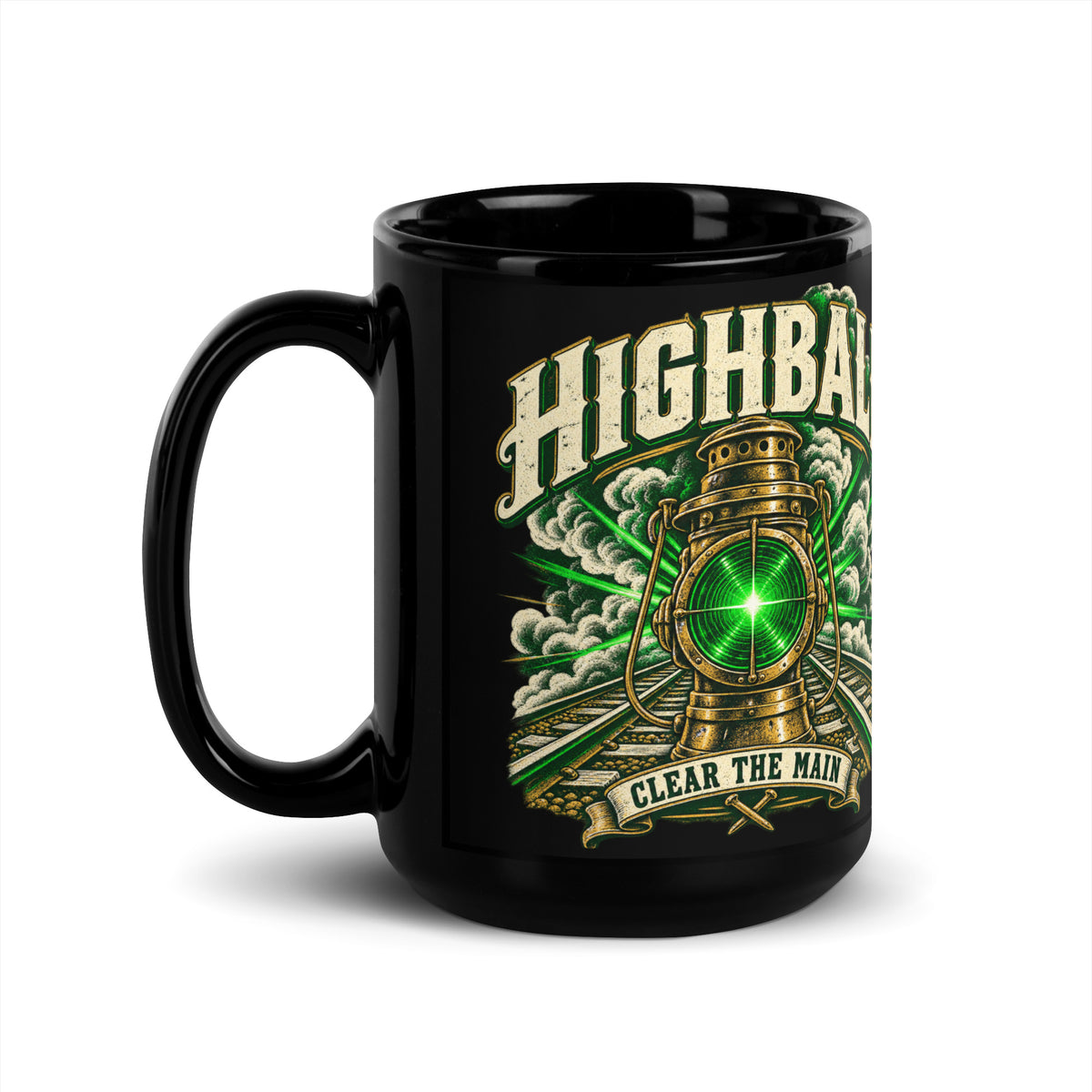 Black glossy 15 oz ceramic mug featuring a vintage brass railroad lantern shining a bright green light over train tracks surrounded by steam. Large distressed text arched at the top reads "HIGHBALL". A banner at the bottom reads "CLEAR THE MAIN" above crossed railroad spikes.   