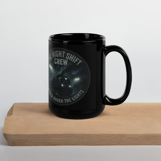 Black mug with 'Night Shift Crew' text on a wooden block against a white background