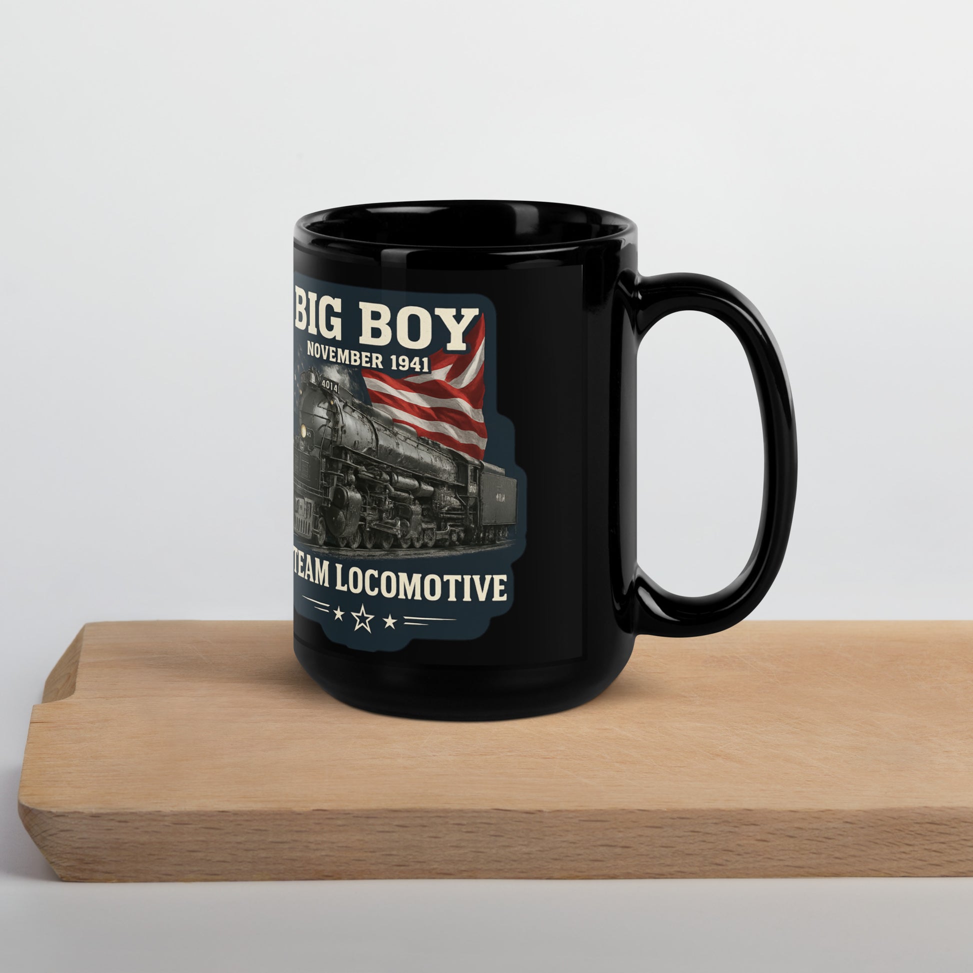 Black 15-ounce glossy coffee mug featuring a vintage graphic of the Big Boy 4014 steam locomotive backed by an American flag, with text reading "BIG BOY", "NOVEMBER 1941", and "STEAM LOCOMOTIVE".