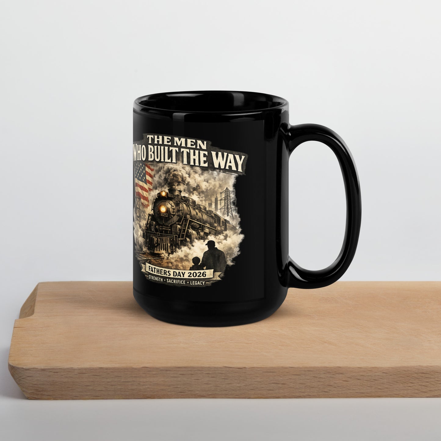 Black 15-ounce glossy coffee mug featuring a cinematic graphic of a steam locomotive, an American flag, and a silhouette of a father and child holding hands, with text reading "The Men Who Built The Way", "Fathers Day 2026", and "Strength - Sacrifice - Legacy".