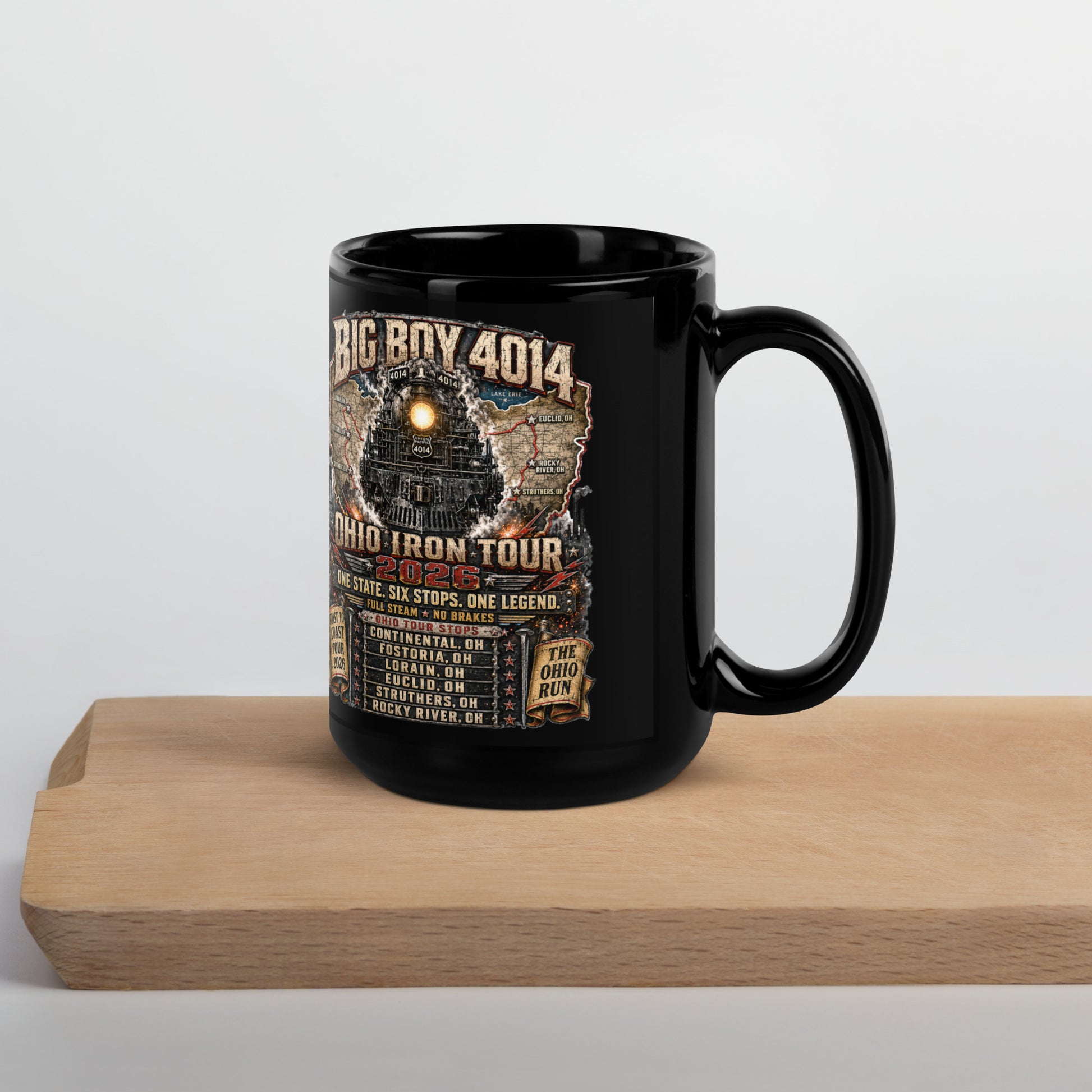 Black 15-ounce glossy coffee mug featuring a highly detailed graphic of the Big Boy 4014 steam locomotive backed by a map of Ohio. Text reads "BIG BOY 4014", "OHIO IRON TOUR 2026", "ONE STATE. SIX STOPS. ONE LEGEND.", alongside banners for "COAST TO COAST TOUR 2026" and "THE OHIO RUN", plus a detailed roster of six Ohio tour stops.