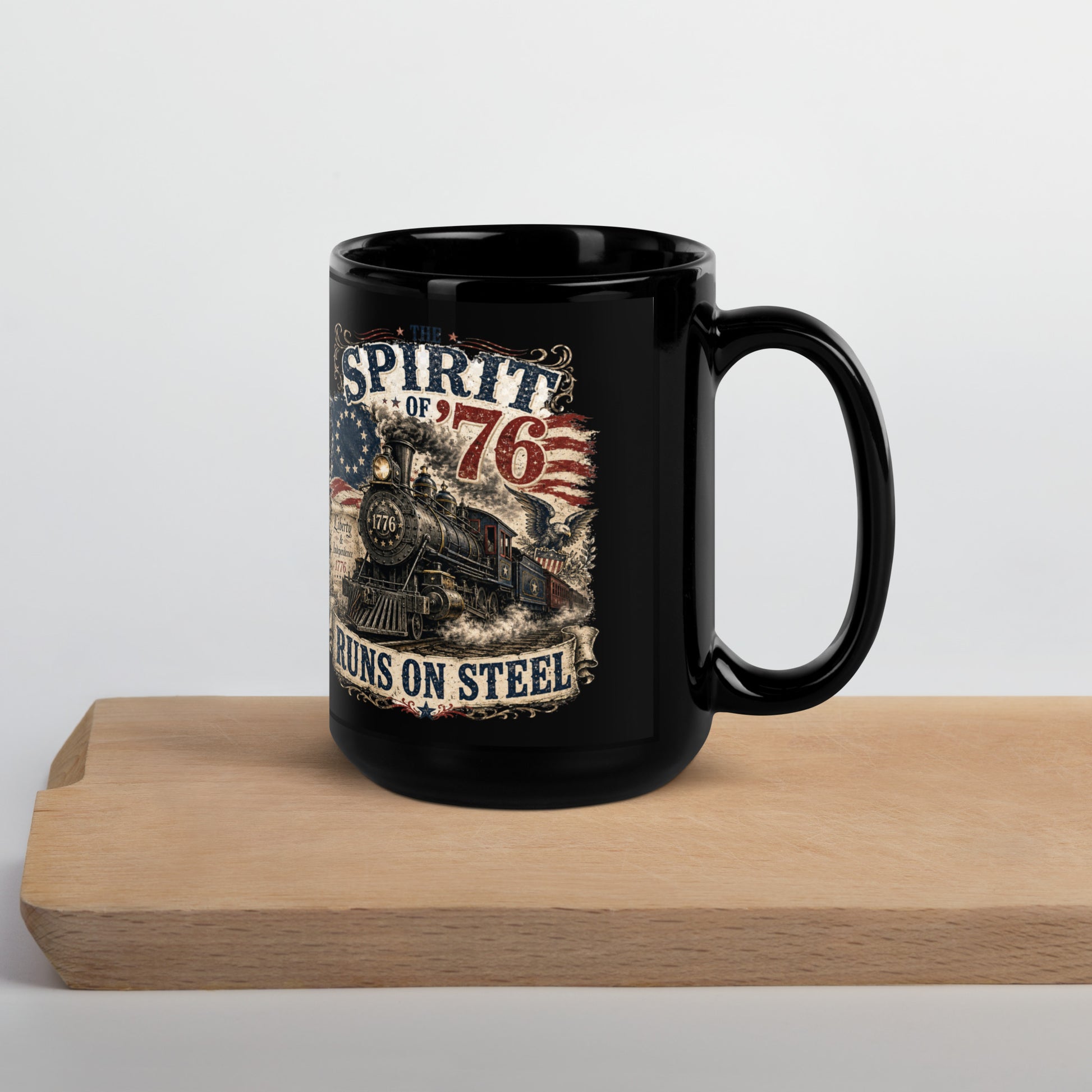 Black 15-ounce glossy coffee mug featuring a highly detailed vintage graphic. Distressed text reads "THE SPIRIT OF '76". The center shows a classic steam locomotive with "1776" on the front plate, bursting from a 13-star Betsy Ross American flag. A bald eagle flies on the right, and a parchment scroll on the left reads "Liberty & Independence 1776". A banner at the bottom reads "RUNS ON STEEL".