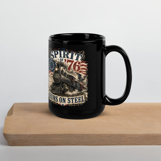 Black 15-ounce glossy coffee mug featuring a highly detailed vintage graphic. Distressed text reads "THE SPIRIT OF '76". The center shows a classic steam locomotive with "1776" on the front plate, bursting from a 13-star Betsy Ross American flag. A bald eagle flies on the right, and a parchment scroll on the left reads "Liberty & Independence 1776". A banner at the bottom reads "RUNS ON STEEL".