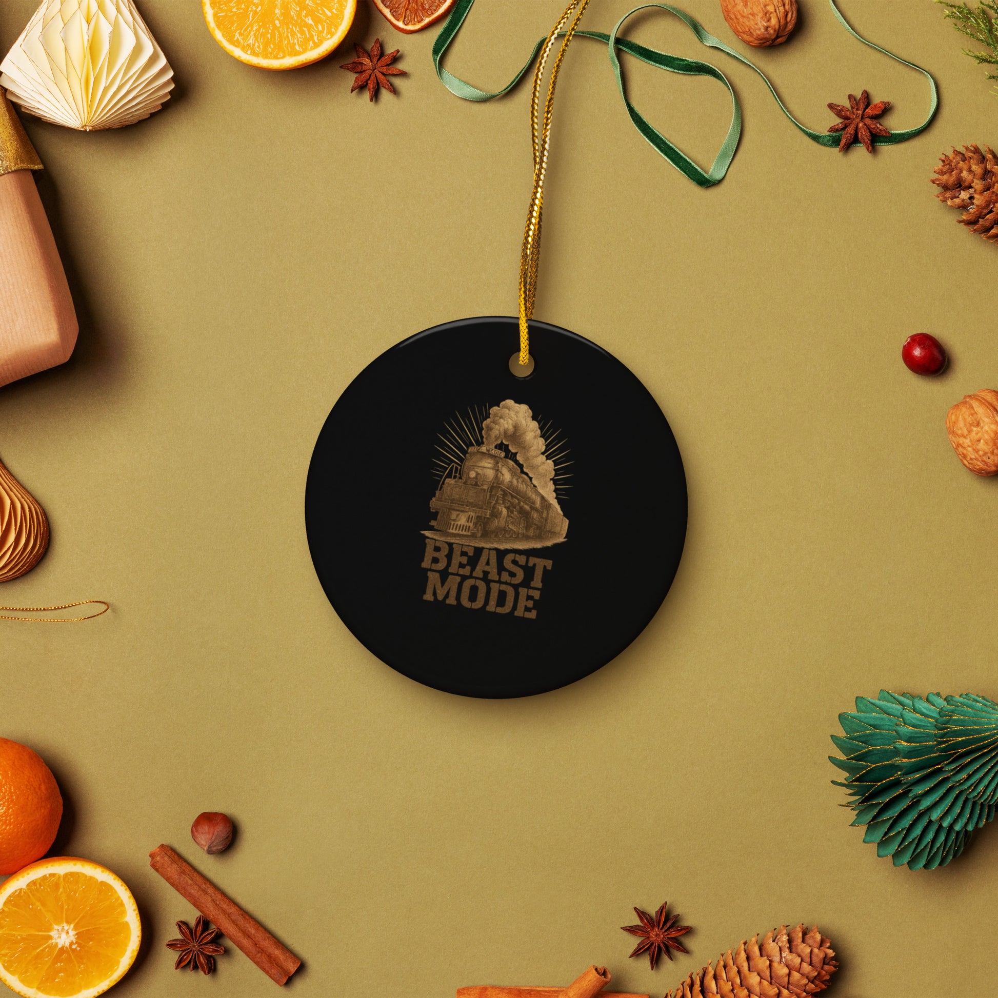 Black ornament with 'Beast Mode' text on a festive background with oranges, cinnamon sticks, and pine cones.
