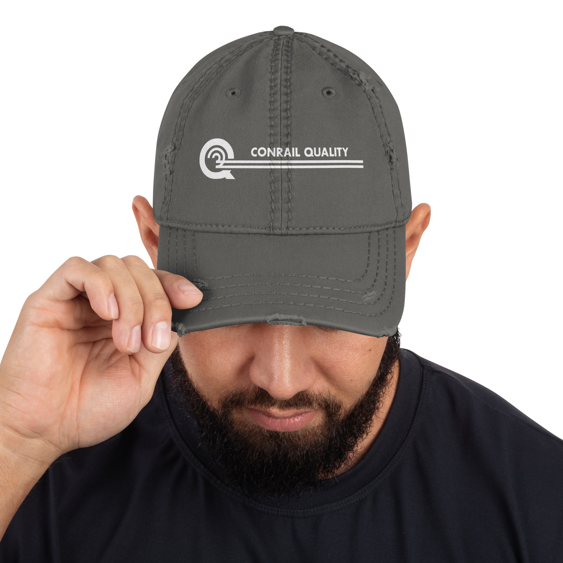Man holding a gray cap with 'Conrail Quality' logo against a white background
