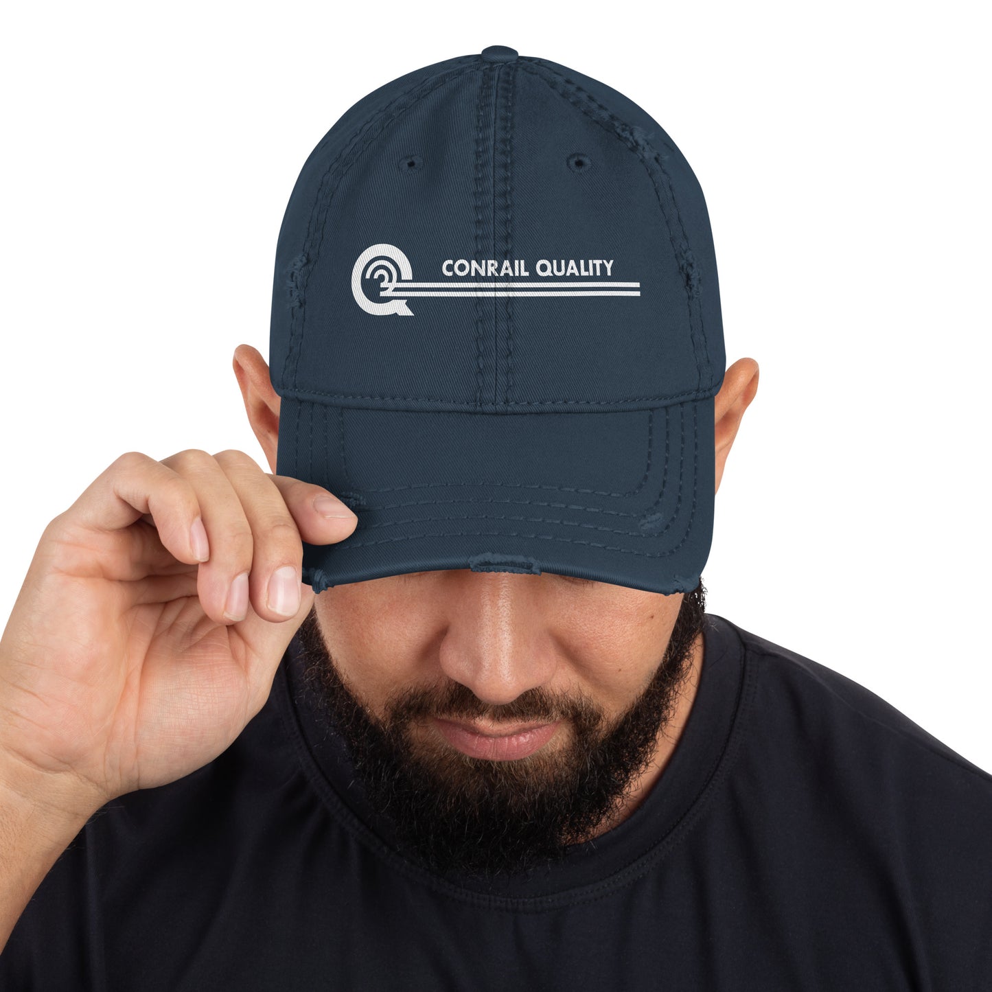 Man holding a navy blue cap with 'Conrail Quality' logo on a white background