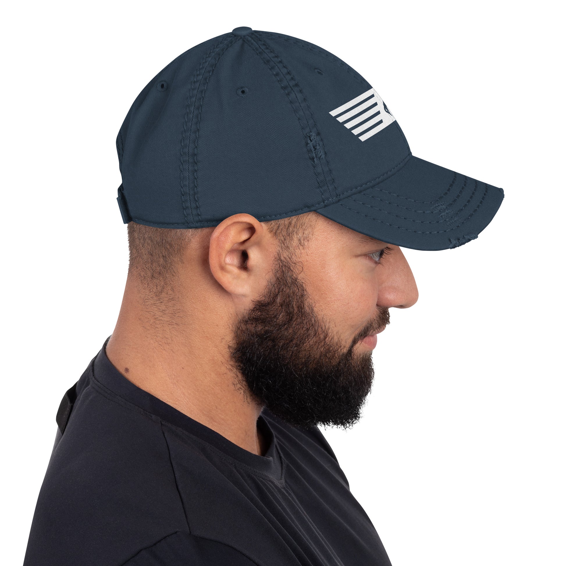 Man wearing a navy cap with a white logo on a white background