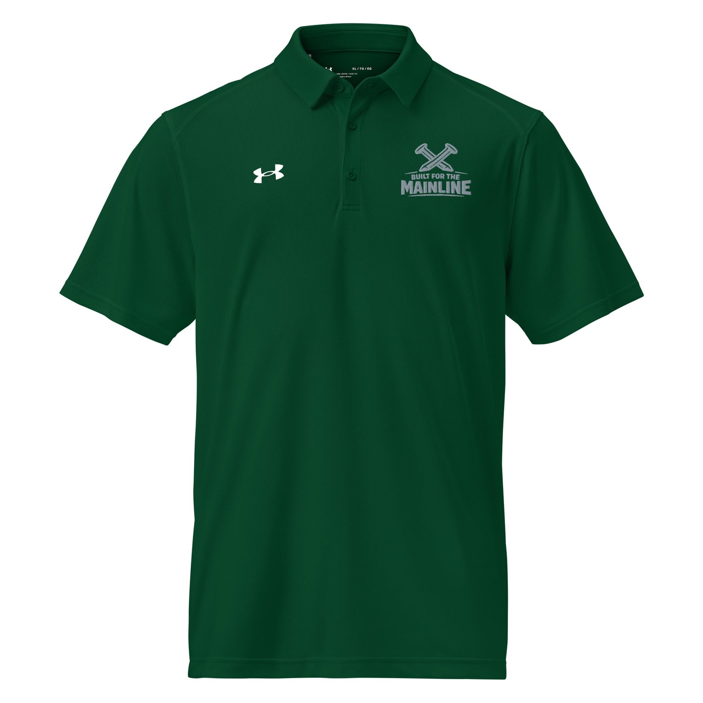 Forest green Under Armour men's polo shirt featuring a graphic of crossed railroad spikes above the text "BUILT FOR THE MAINLINE" on the left chest. A white Under Armour logo is displayed on the right chest. The shirt has a classic collar and a multi-button placket.
