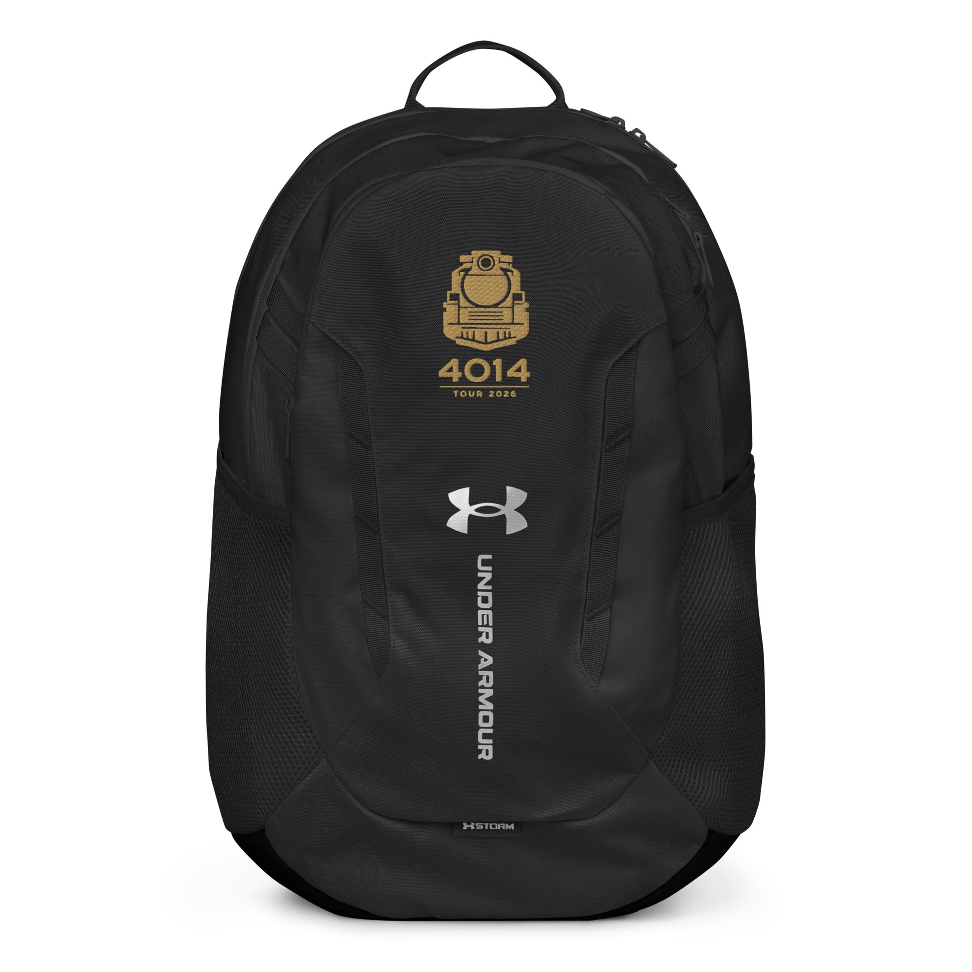 Black Under Armour backpack featuring a gold graphic of a front-facing steam locomotive above the text "4014 TOUR 2026". The silver Under Armour logo is centered on the front above the vertical text "UNDER ARMOUR". The bottom of the bag features the UA Storm technology badge.
