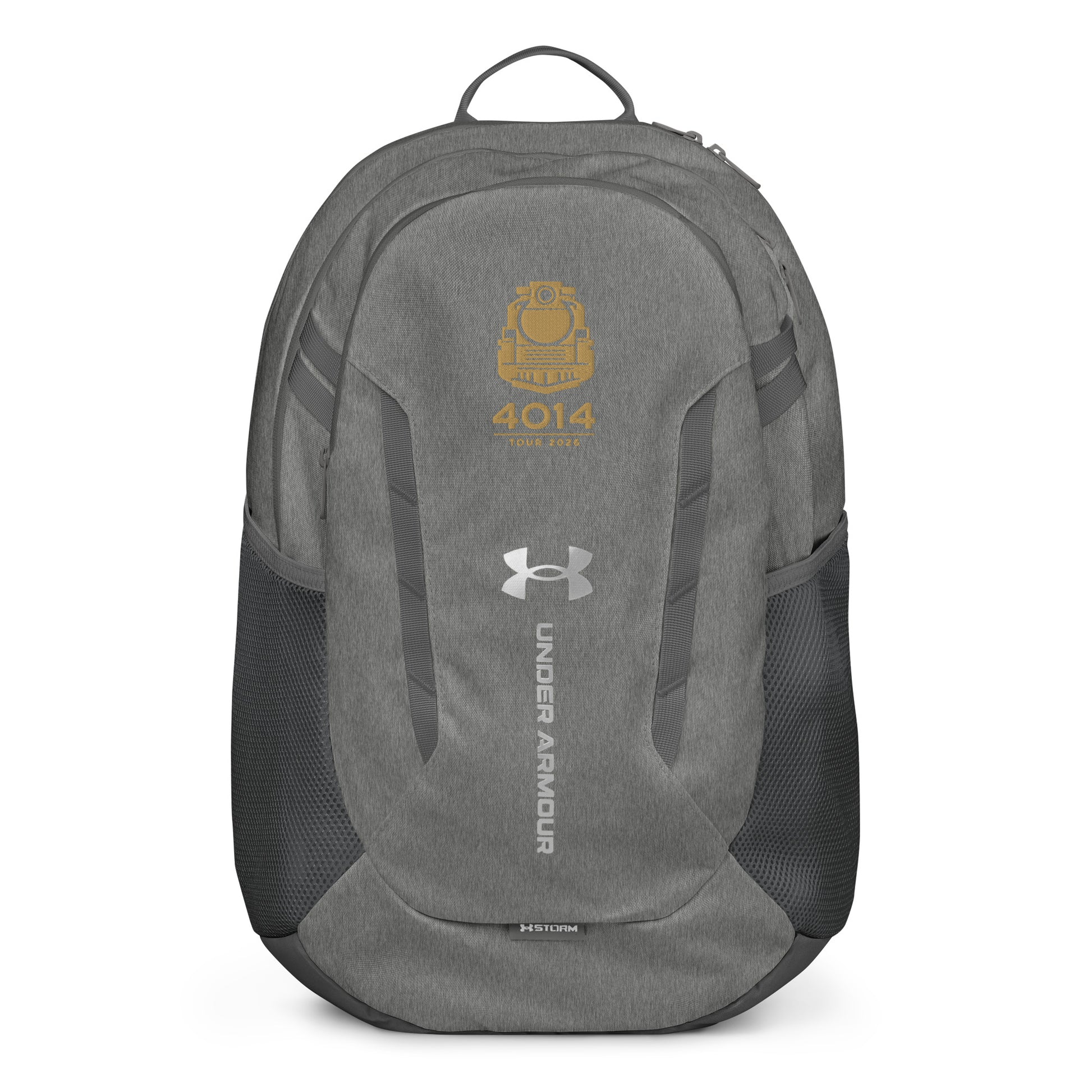 Silver Under Armour backpack featuring a gold graphic of a front-facing steam locomotive above the text "4014 TOUR 2026". The silver Under Armour logo is centered on the front above the vertical text "UNDER ARMOUR". The bottom of the bag features the UA Storm technology badge.