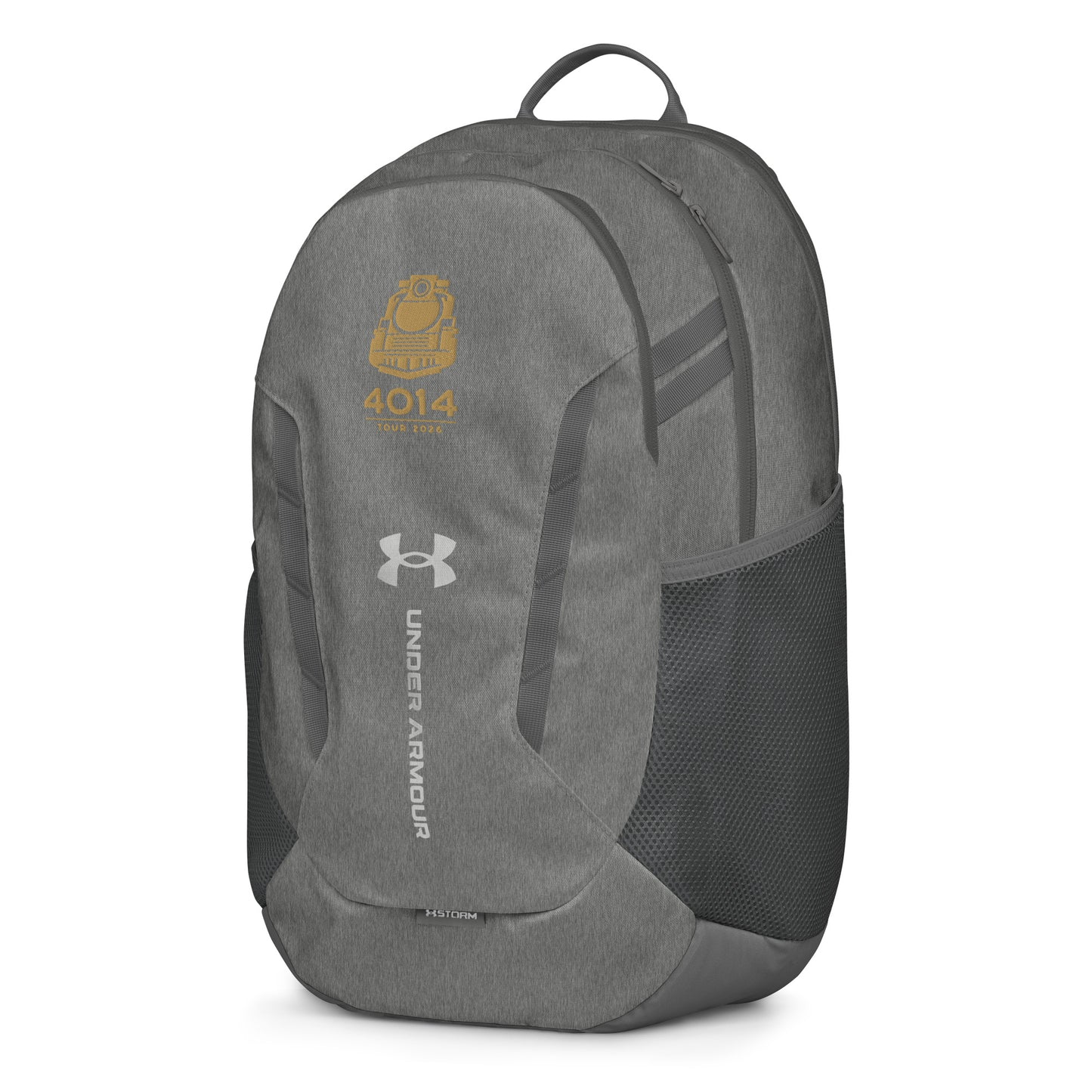 Silver Under Armour backpack featuring a gold graphic of a front-facing steam locomotive above the text "4014 TOUR 2026". The silver Under Armour logo is centered on the front above the vertical text "UNDER ARMOUR". The bottom of the bag features the UA Storm technology badge.