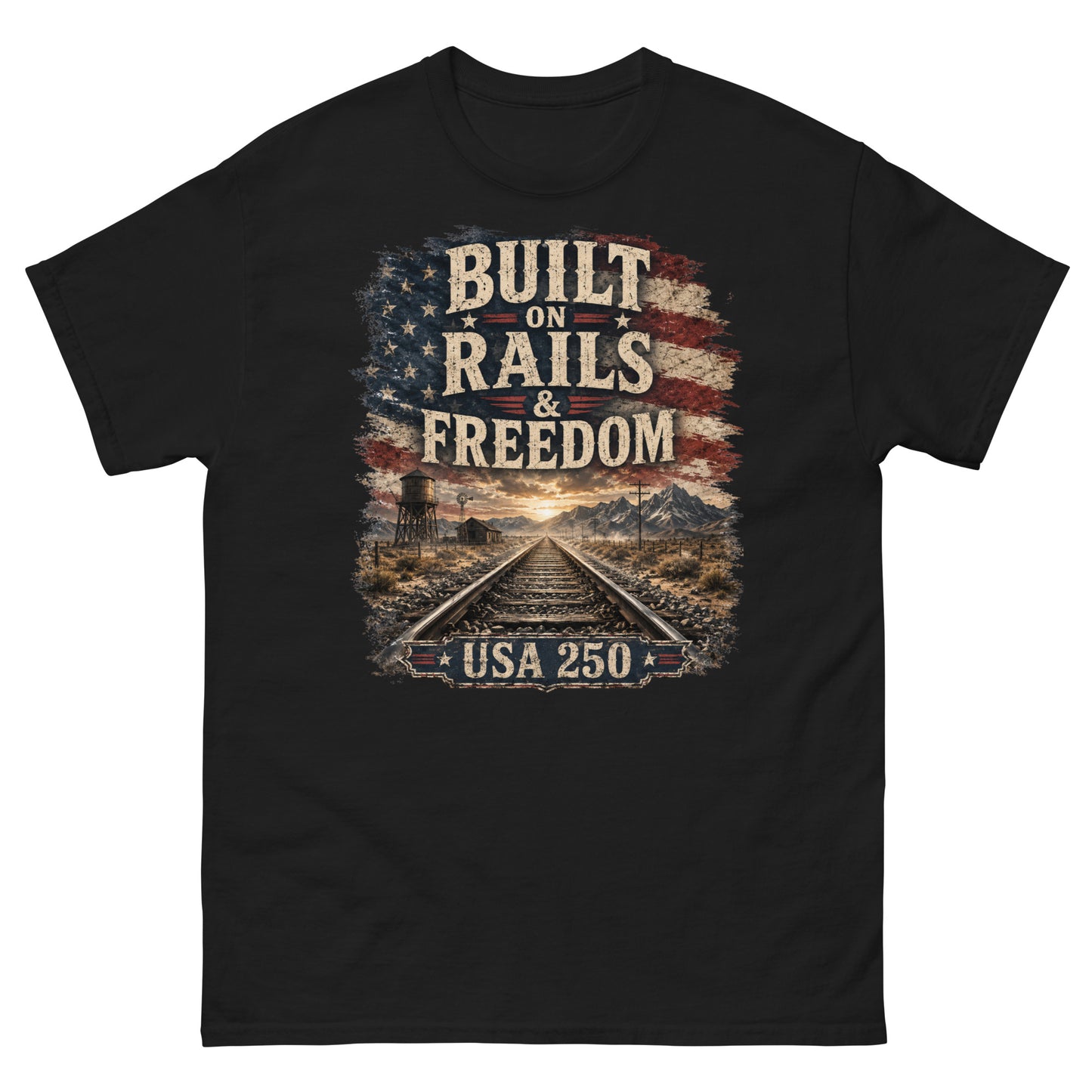 Black t-shirt featuring a distressed American flag graphic at the top with text reading "BUILT ON RAILS & FREEDOM". Below the text is a landscape illustration of railroad tracks leading toward mountains and a sunset, with a trackside water tower on the left. A banner at the bottom reads "USA 250".