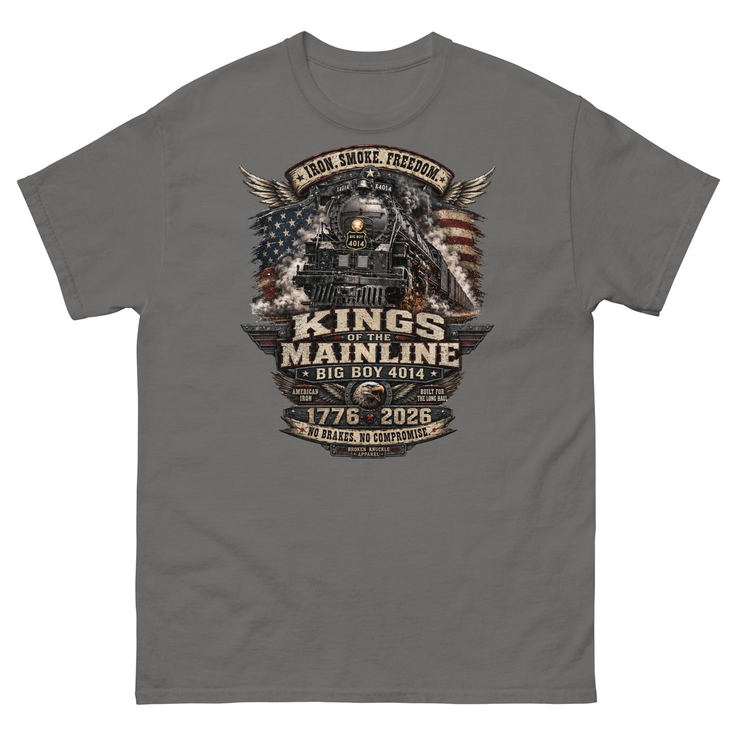 Gray t-shirt featuring a highly detailed patriotic graphic. The Big Boy 4014 steam locomotive is centered against a distressed American flag and wings. A banner at the top reads "IRON. SMOKE. FREEDOM." Large text reads "KINGS OF THE MAINLINE" and "BIG BOY 4014". Below is a bald eagle head between badges reading "AMERICAN IRON" and "BUILT FOR THE LONG HAUL". The bottom features "1776 - 2026", "NO BRAKES. NO COMPROMISE.", and "BROKEN KNUCKLE APPAREL".