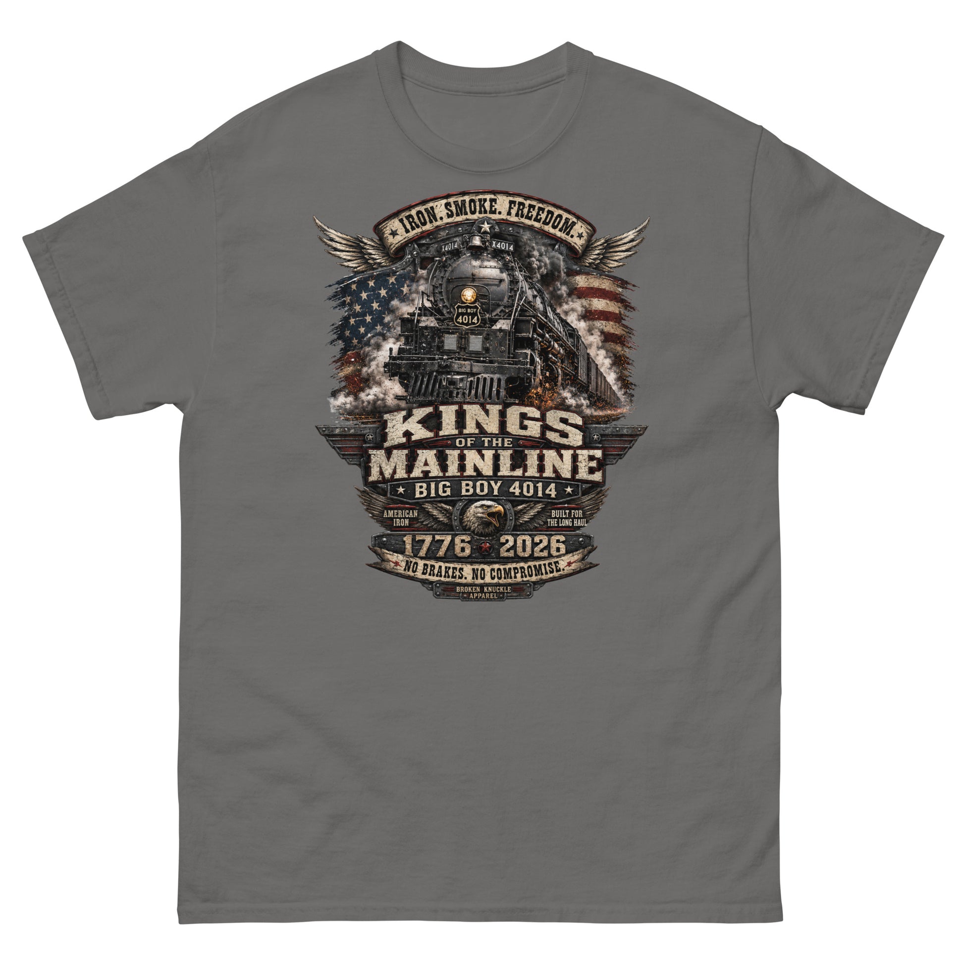 Gray t-shirt featuring a highly detailed patriotic graphic. The Big Boy 4014 steam locomotive is centered against a distressed American flag and wings. A banner at the top reads "IRON. SMOKE. FREEDOM." Large text reads "KINGS OF THE MAINLINE" and "BIG BOY 4014". Below is a bald eagle head between badges reading "AMERICAN IRON" and "BUILT FOR THE LONG HAUL". The bottom features "1776 - 2026", "NO BRAKES. NO COMPROMISE.", and "BROKEN KNUCKLE APPAREL".