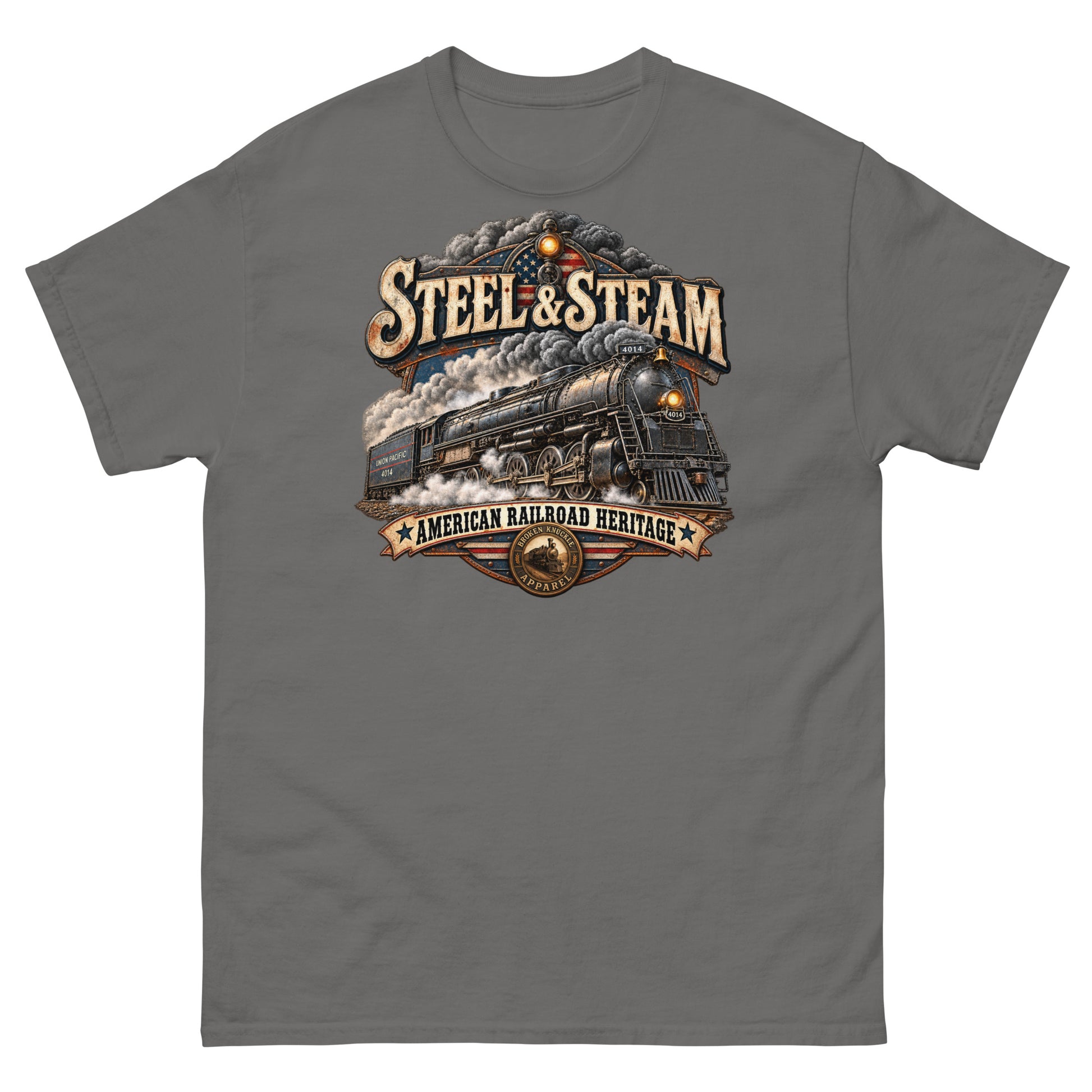 Charcoal classic t-shirt featuring a highly detailed vintage graphic. A steam locomotive charges forward surrounded by smoke, with an American flag motif in the background. Vintage distressed text reads "STEEL & STEAM" at the top and "AMERICAN RAILROAD HERITAGE" on a banner at the bottom, just above a round Broken Knuckle Apparel badge.