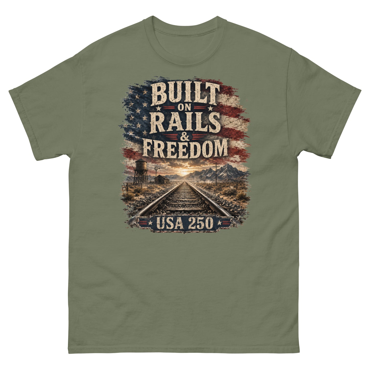 Army green t-shirt featuring a distressed American flag graphic at the top with text reading "BUILT ON RAILS & FREEDOM". Below the text is a landscape illustration of railroad tracks leading toward mountains and a sunset, with a trackside water tower on the left. A banner at the bottom reads "USA 250".