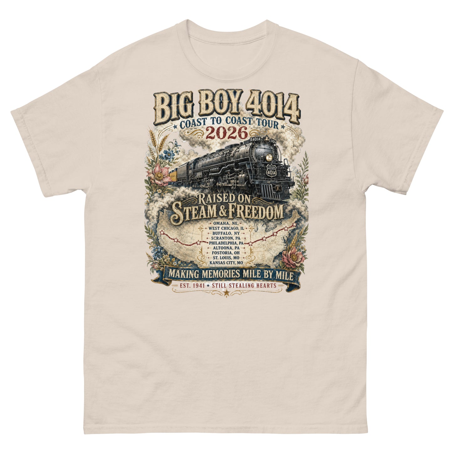 Natural t-shirt featuring a vintage graphic of the Big Boy 4014 steam locomotive. The train is surrounded by steam, classic floral designs, and a route map. Text reads "BIG BOY 4014", "COAST TO COAST TOUR 2026", and "RAISED ON STEAM & FREEDOM". Below is a roster of nine tour stops, anchored by banners reading "MAKING MEMORIES MILE BY MILE" and "EST. 1941 STILL STEALING HEARTS".