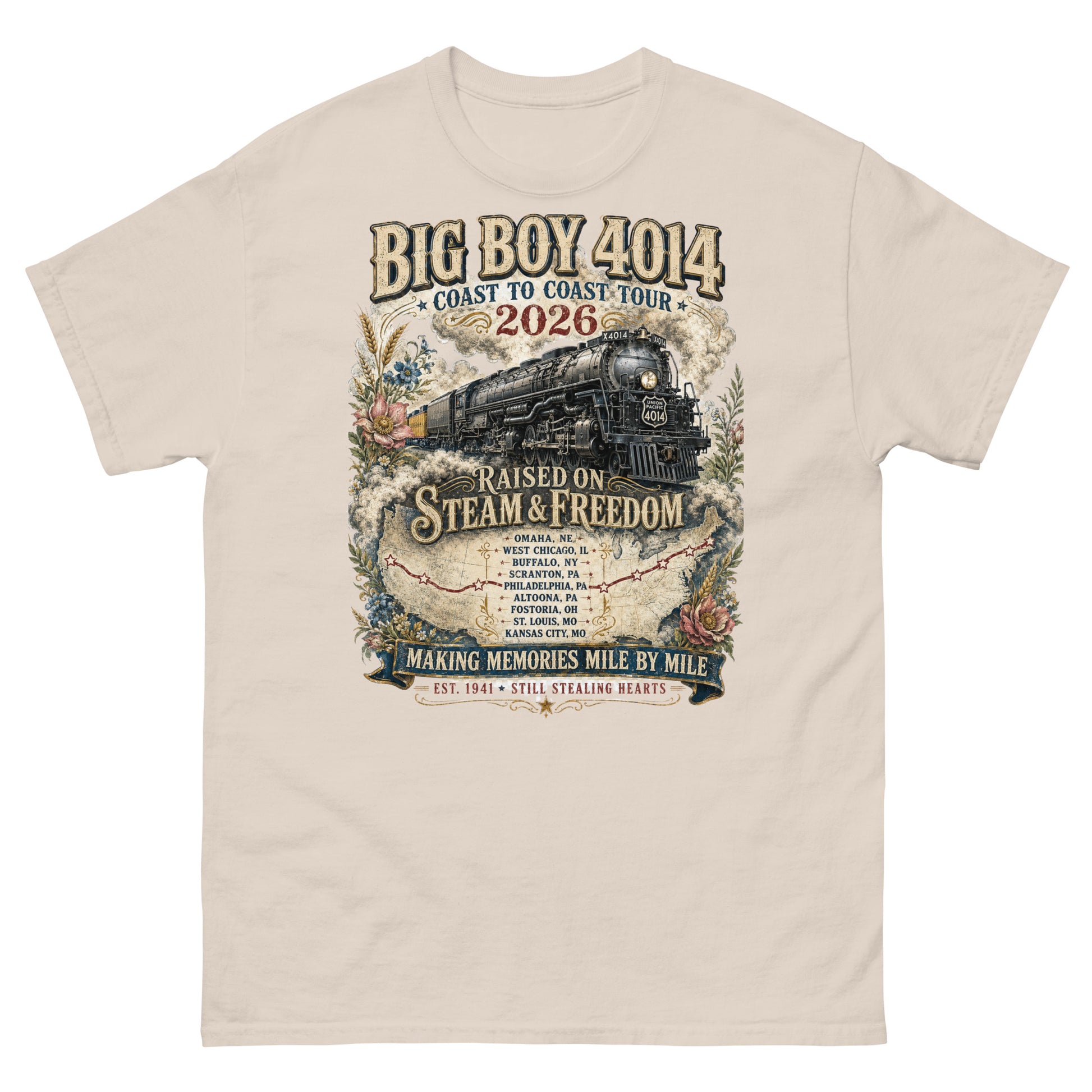 Natural t-shirt featuring a vintage graphic of the Big Boy 4014 steam locomotive. The train is surrounded by steam, classic floral designs, and a route map. Text reads "BIG BOY 4014", "COAST TO COAST TOUR 2026", and "RAISED ON STEAM & FREEDOM". Below is a roster of nine tour stops, anchored by banners reading "MAKING MEMORIES MILE BY MILE" and "EST. 1941 STILL STEALING HEARTS".
