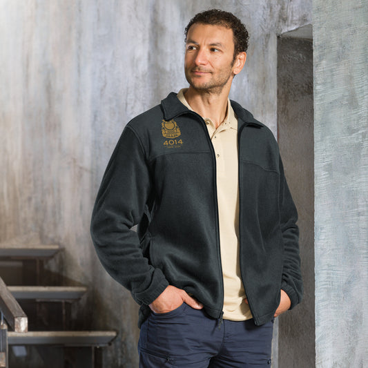 Man wearing a Dark grey Columbia full-zip fleece jacket featuring a gold embroidered graphic of a front-facing steam locomotive above the text "4014 TOUR 2026" on the right chest. A white Columbia logo is visible on the left sleeve.