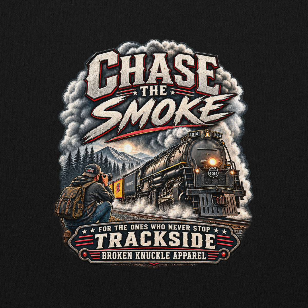 Black heavy blend pullover hoodie featuring a graphic of a photographer with a backpack kneeling trackside, taking a picture of a large steam locomotive rolling through a forest landscape. Bold distressed text reads "CHASE THE SMOKE" at the top and "FOR THE ONES WHO NEVER STOP TRACKSIDE" in a vintage banner at the bottom.