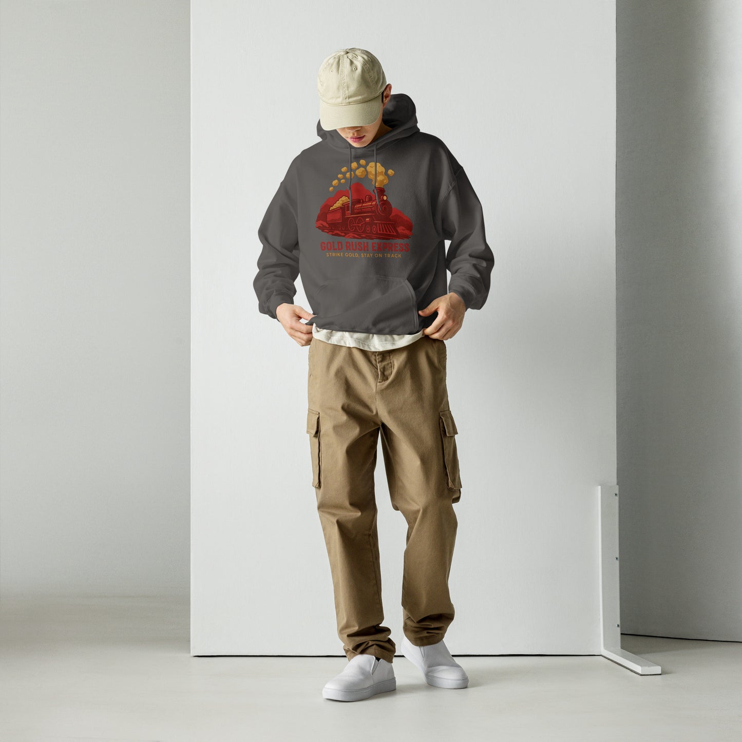 Person wearing a gray hoodie with a red graphic and brown cargo pants on a white background