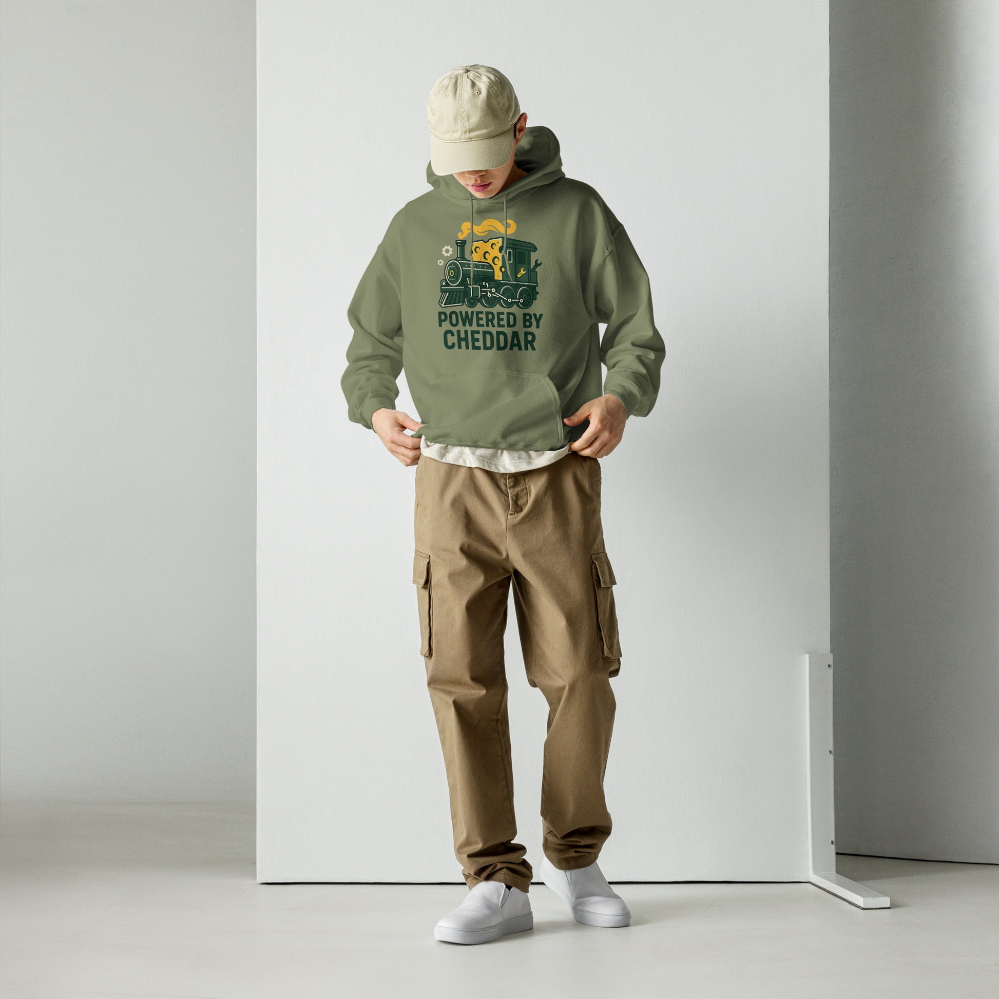 Person wearing a green hoodie with text and graphics, brown cargo pants, and white shoes on a plain background