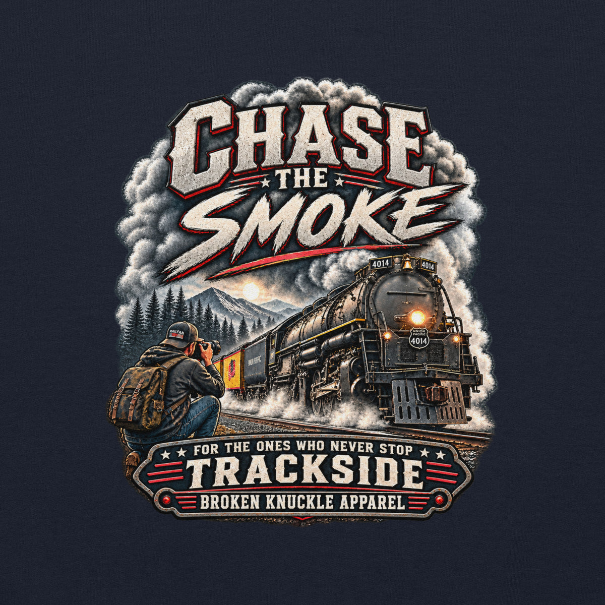 Navy heavy blend pullover hoodie featuring a graphic of a photographer with a backpack kneeling trackside, taking a picture of a large steam locomotive rolling through a forest landscape. Bold distressed text reads "CHASE THE SMOKE" at the top and "FOR THE ONES WHO NEVER STOP TRACKSIDE" in a vintage banner at the bottom.