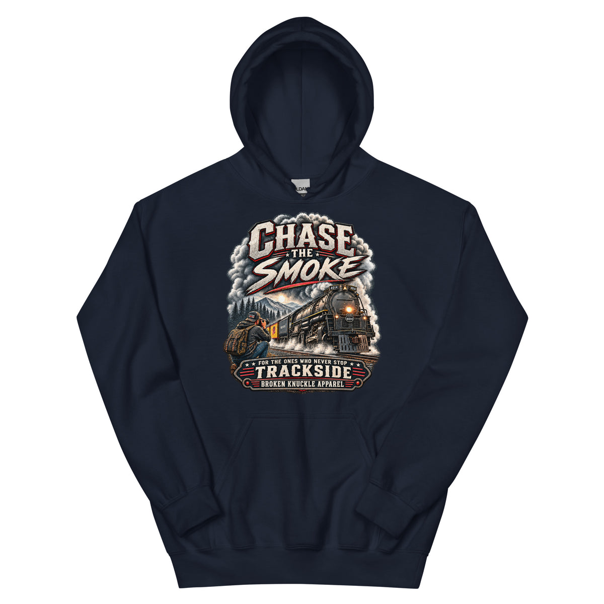 Navy heavy blend pullover hoodie featuring a graphic of a photographer with a backpack kneeling trackside, taking a picture of a large steam locomotive rolling through a forest landscape. Bold distressed text reads "CHASE THE SMOKE" at the top and "FOR THE ONES WHO NEVER STOP TRACKSIDE" in a vintage banner at the bottom.
