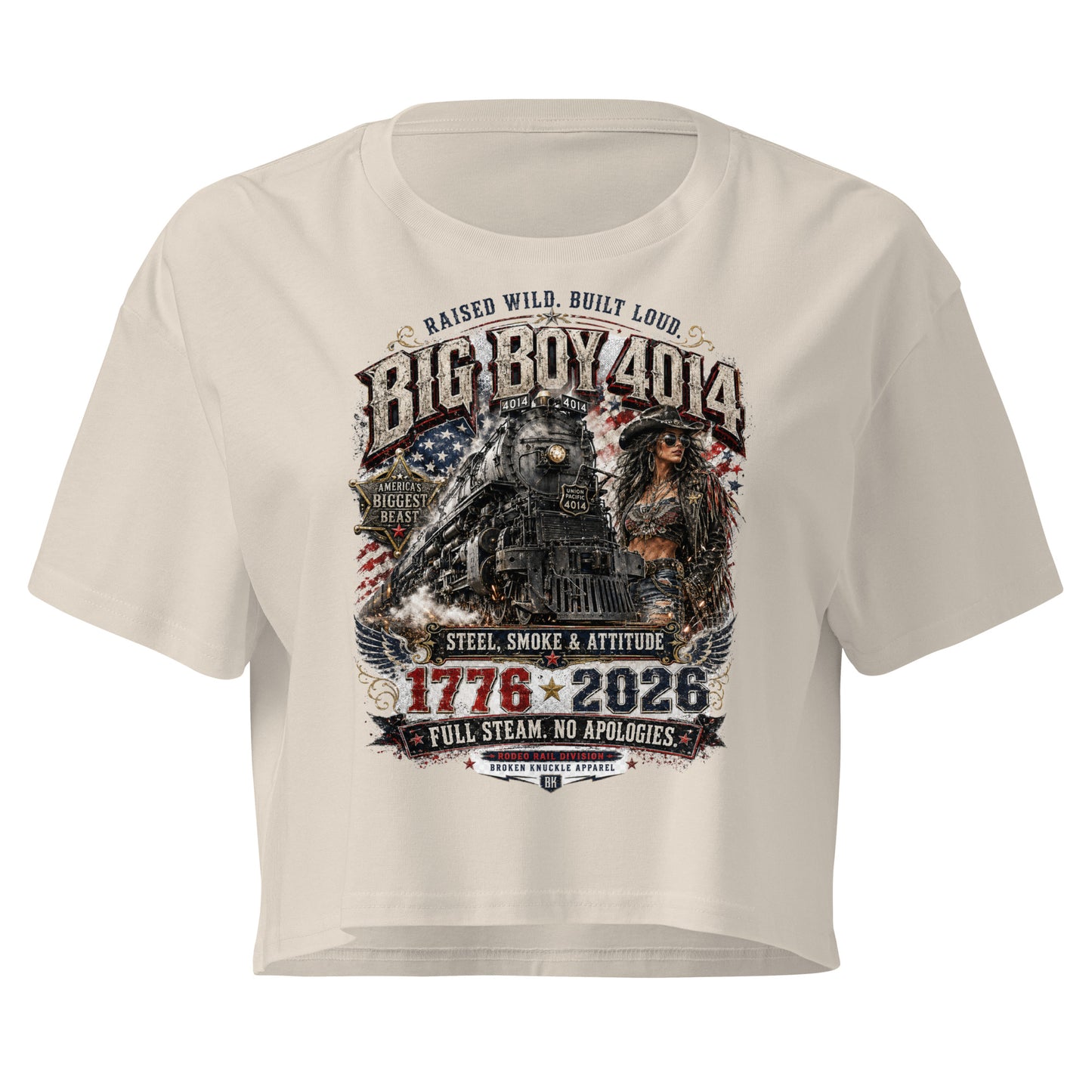 Bone women's crop top featuring a gritty graphic of the Big Boy 4014 steam locomotive next to a woman in a cowboy hat and leather jacket. The background includes a distressed American flag and eagle wings. Text reads "RAISED WILD. BUILT LOUD.", "BIG BOY 4014", "AMERICA'S BIGGEST BEAST", "STEEL, SMOKE & ATTITUDE", "1776 - 2026", "FULL STEAM. NO APOLOGIES.", and "RODEO RAIL DIVISION".