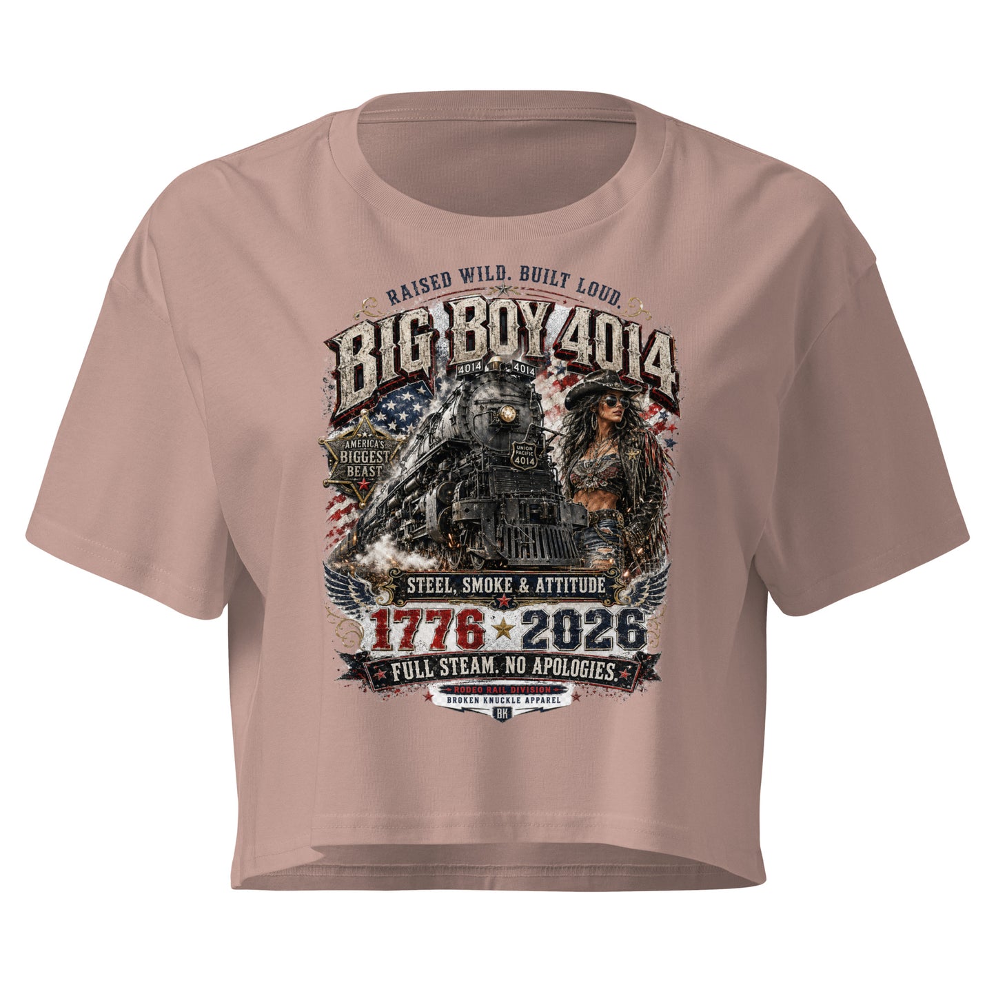 Beige women's crop top featuring a gritty graphic of the Big Boy 4014 steam locomotive next to a woman in a cowboy hat and leather jacket. The background includes a distressed American flag and eagle wings. Text reads "RAISED WILD. BUILT LOUD.", "BIG BOY 4014", "AMERICA'S BIGGEST BEAST", "STEEL, SMOKE & ATTITUDE", "1776 - 2026", "FULL STEAM. NO APOLOGIES.", and "RODEO RAIL DIVISION".