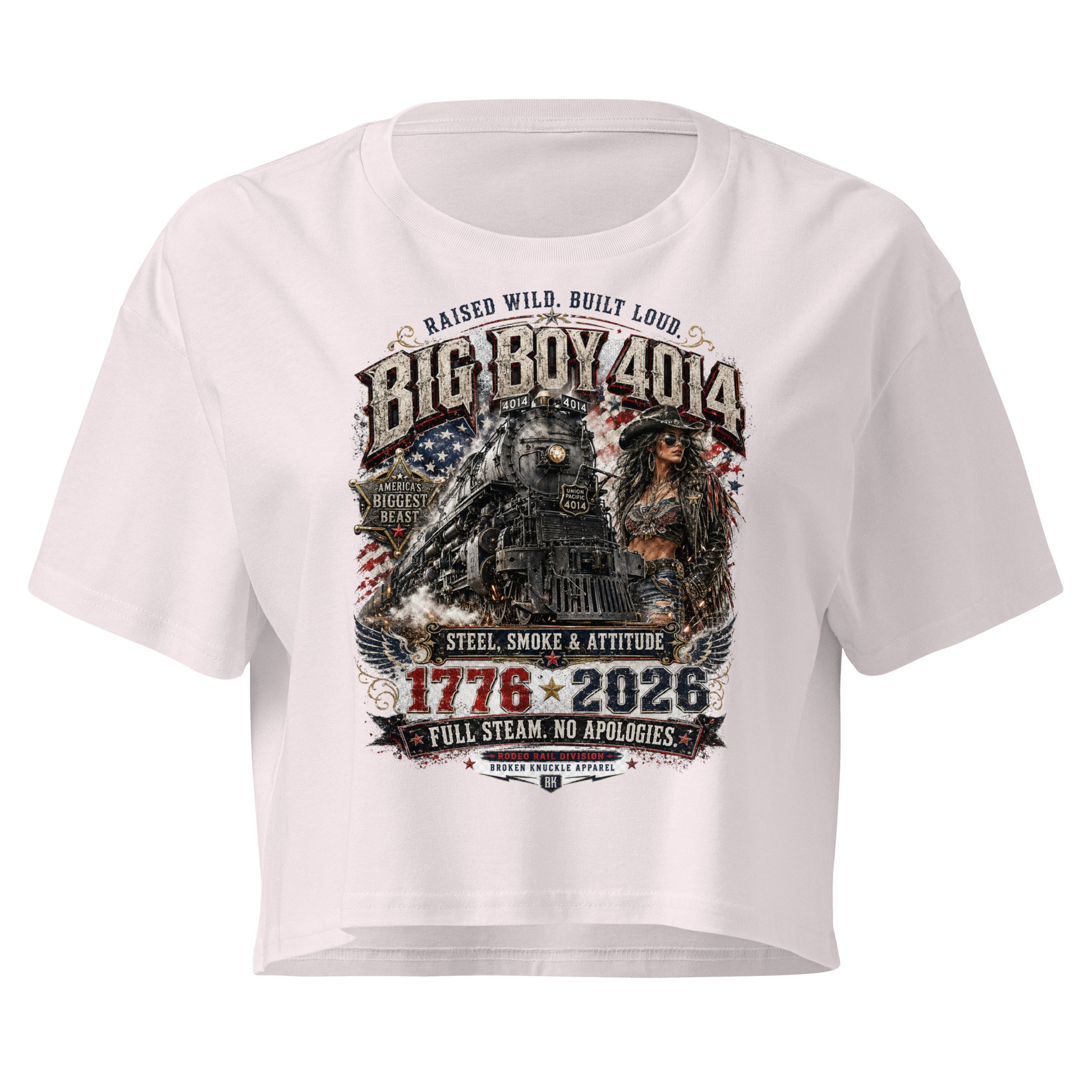 Orchid women's crop top featuring a gritty graphic of the Big Boy 4014 steam locomotive next to a woman in a cowboy hat and leather jacket. The background includes a distressed American flag and eagle wings. Text reads "RAISED WILD. BUILT LOUD.", "BIG BOY 4014", "AMERICA'S BIGGEST BEAST", "STEEL, SMOKE & ATTITUDE", "1776 - 2026", "FULL STEAM. NO APOLOGIES.", and "RODEO RAIL DIVISION".