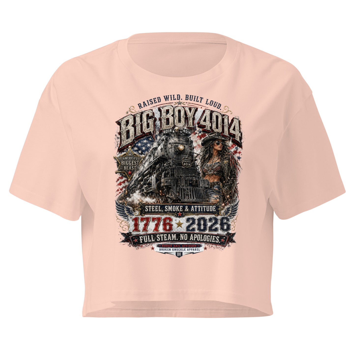 Light Pink women's crop top featuring a gritty graphic of the Big Boy 4014 steam locomotive next to a woman in a cowboy hat and leather jacket. The background includes a distressed American flag and eagle wings. Text reads "RAISED WILD. BUILT LOUD.", "BIG BOY 4014", "AMERICA'S BIGGEST BEAST", "STEEL, SMOKE & ATTITUDE", "1776 - 2026", "FULL STEAM. NO APOLOGIES.", and "RODEO RAIL DIVISION".