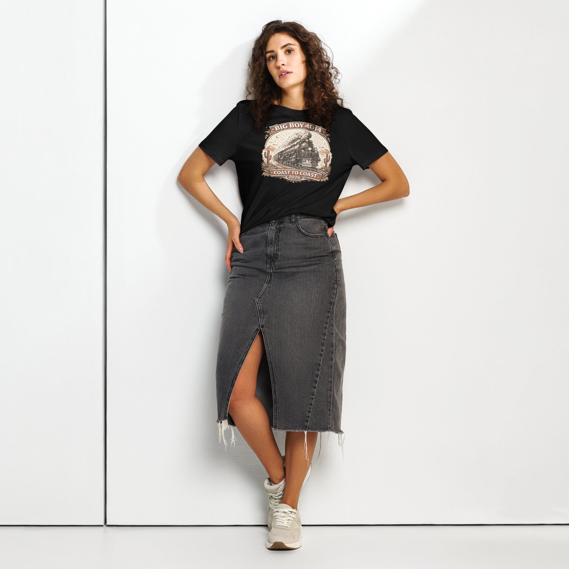 Woman wearing a black t-shirt with a graphic design and a denim skirt on a white background