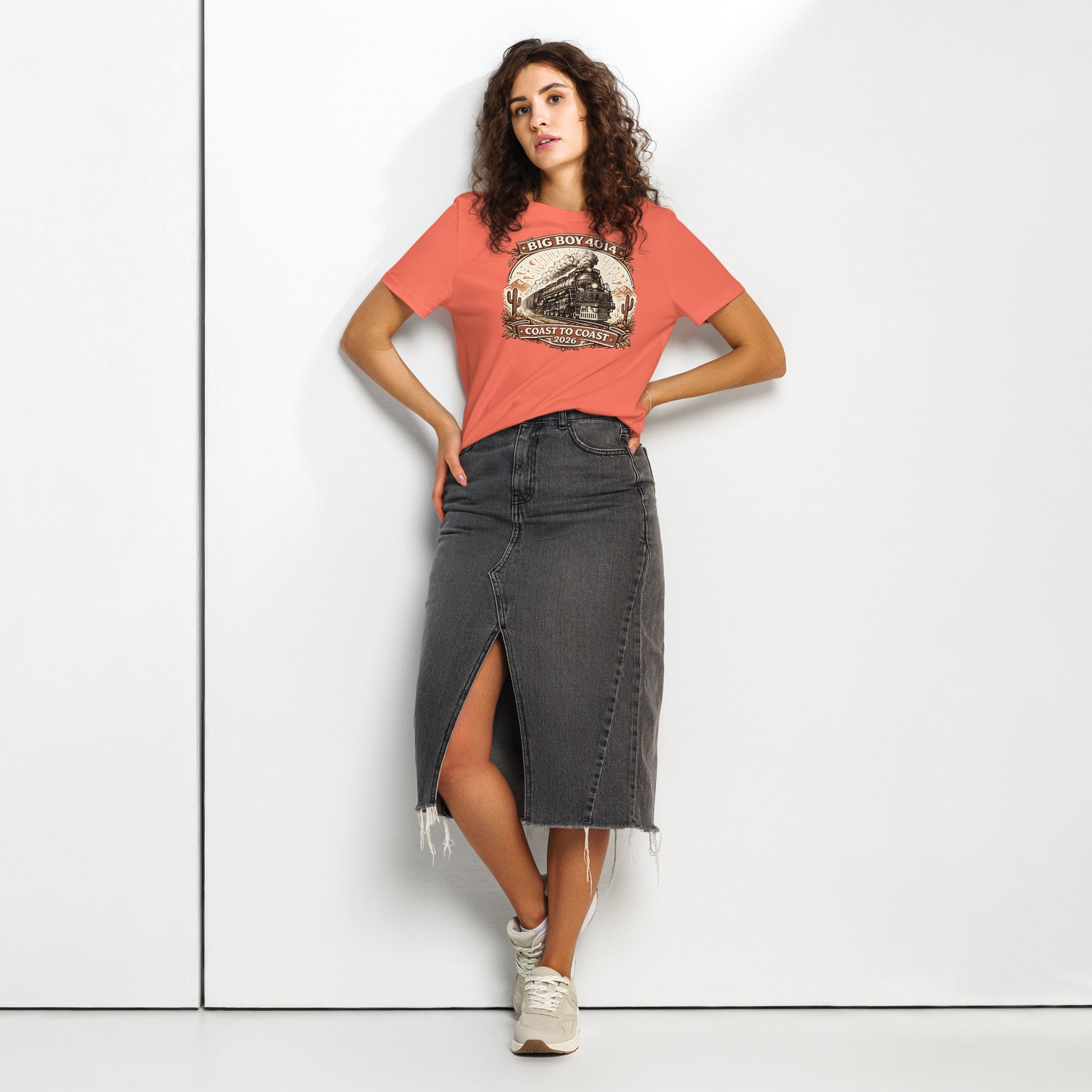 Woman wearing a red t-shirt with a graphic design and a black denim skirt on a white background