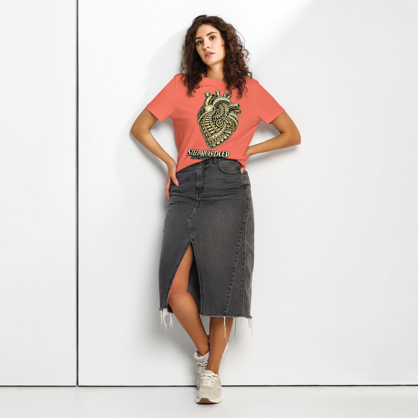 Orange women's t-shirt featuring an intricate vintage illustration of a mechanical heart made of train tracks and gears, with text reading "Steel Runs Deep" and "Coast to Coast 2026".