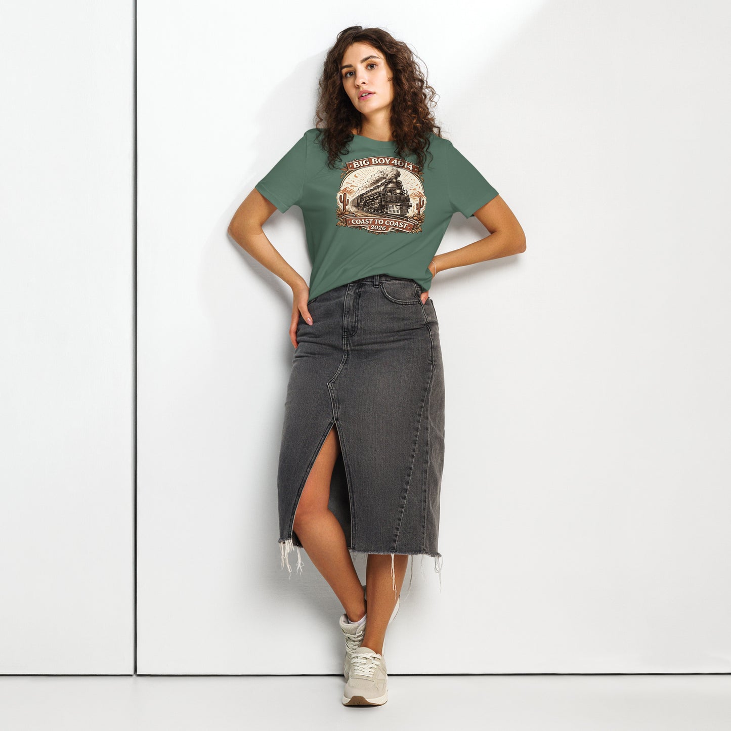 Woman wearing a green t-shirt with a graphic design and a black denim skirt on a white background