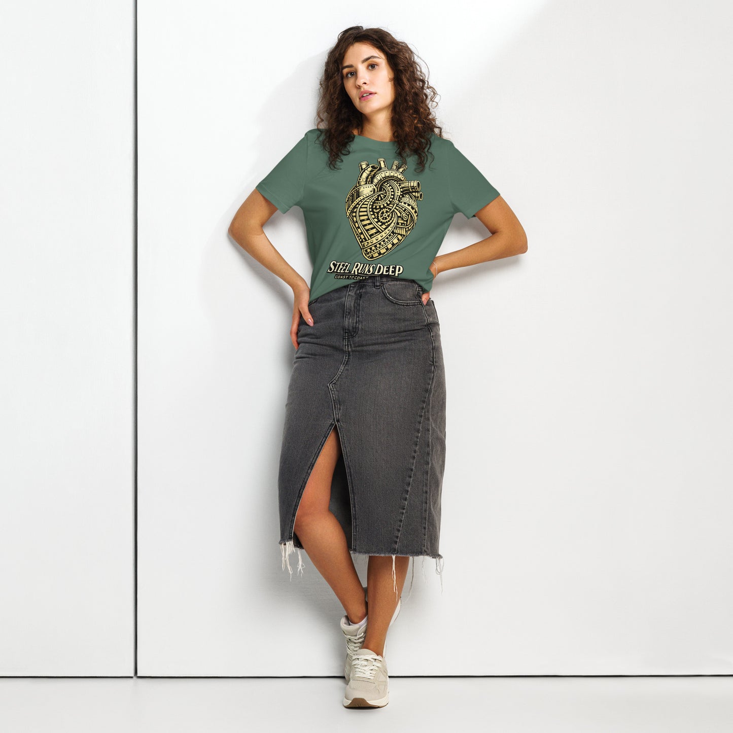 Green women's t-shirt featuring an intricate vintage illustration of a mechanical heart made of train tracks and gears, with text reading "Steel Runs Deep" and "Coast to Coast 2026".