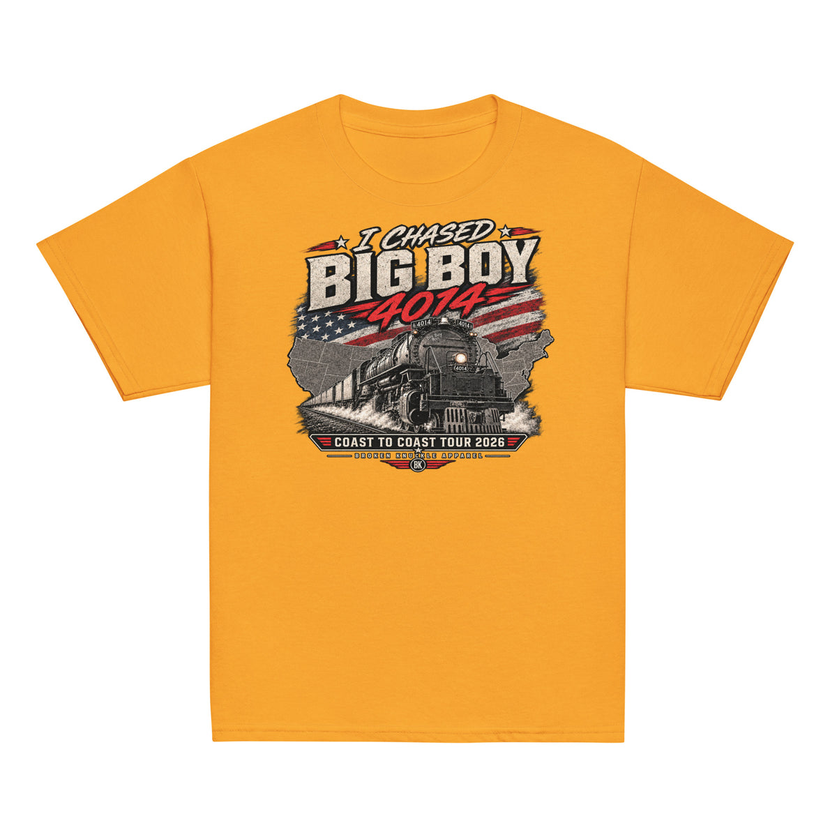 Gold short-sleeve t-shirt featuring a graphic of the Big Boy steam locomotive charging out of a US map with an American flag pattern, surrounded by the text I CHASED BIG BOY 4014 and COAST TO COAST TOUR 2026.